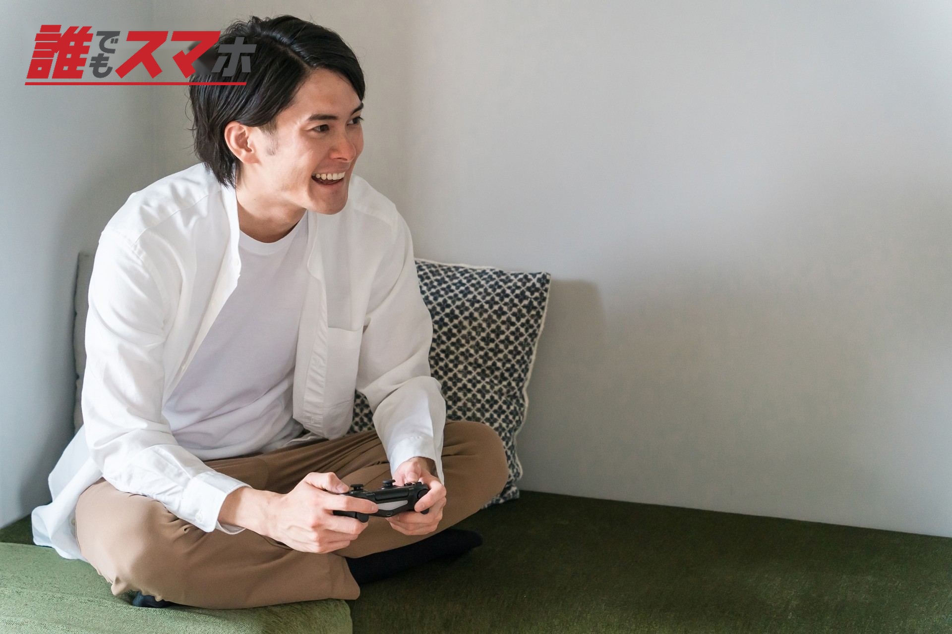 休日に家でオンラインゲームする男性