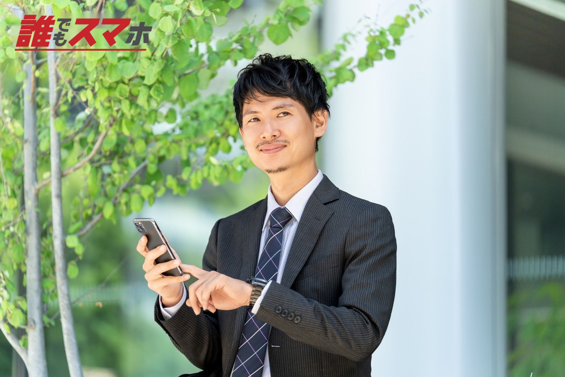 オフィス街でスマホを使う男性ビジネスマン