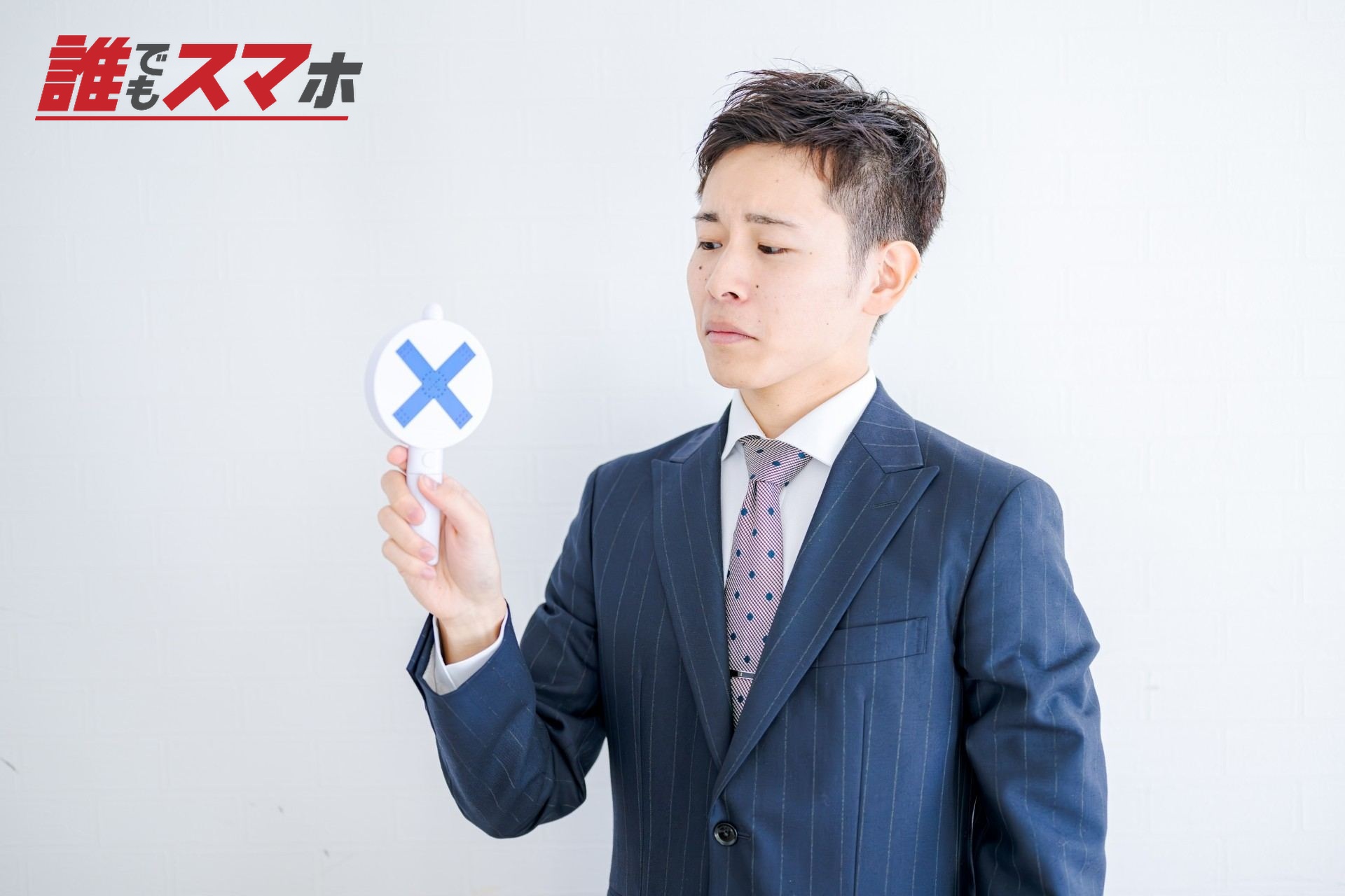 バツマークを持つ男性
