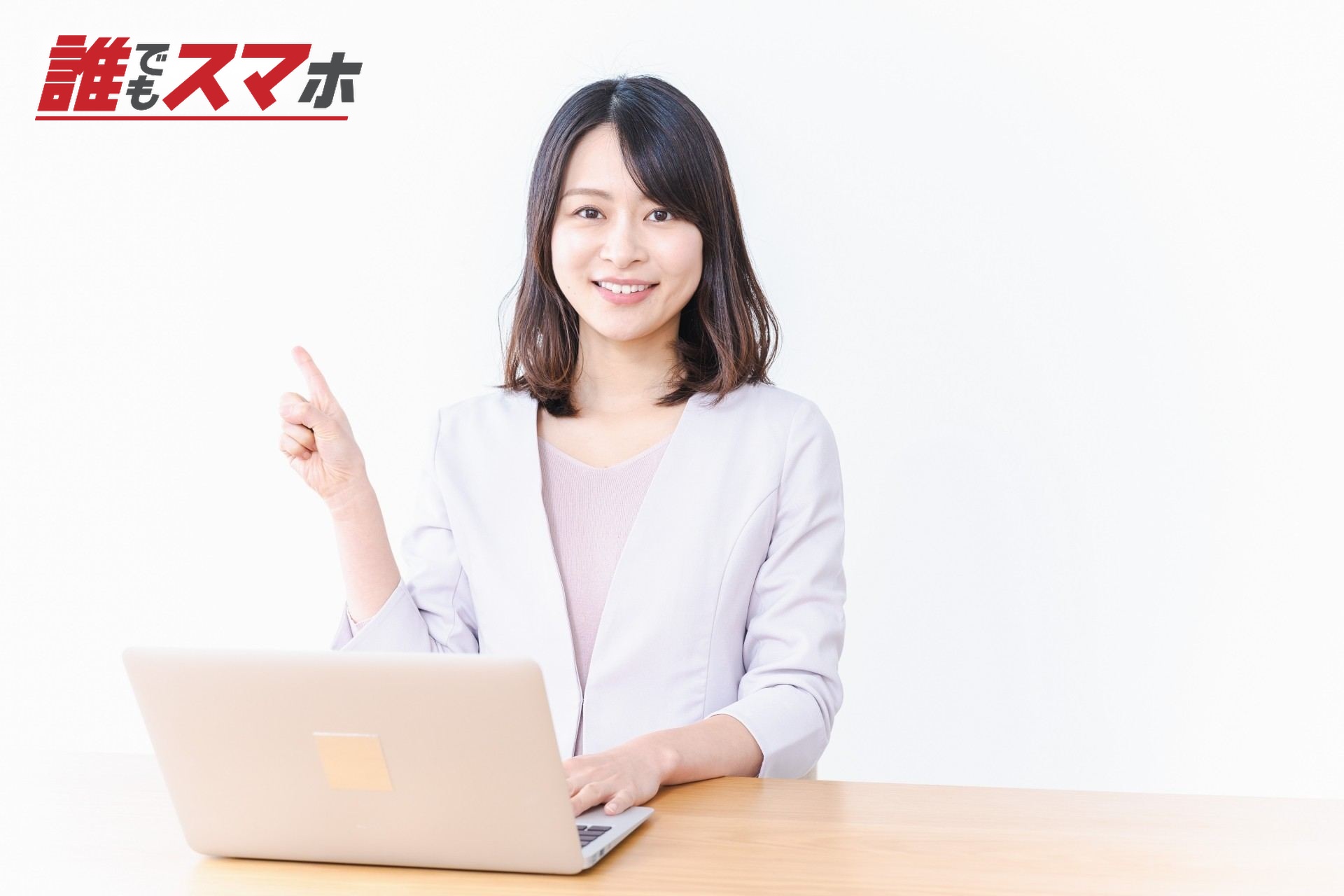 パソコンの前で上に向けて指をさす女性