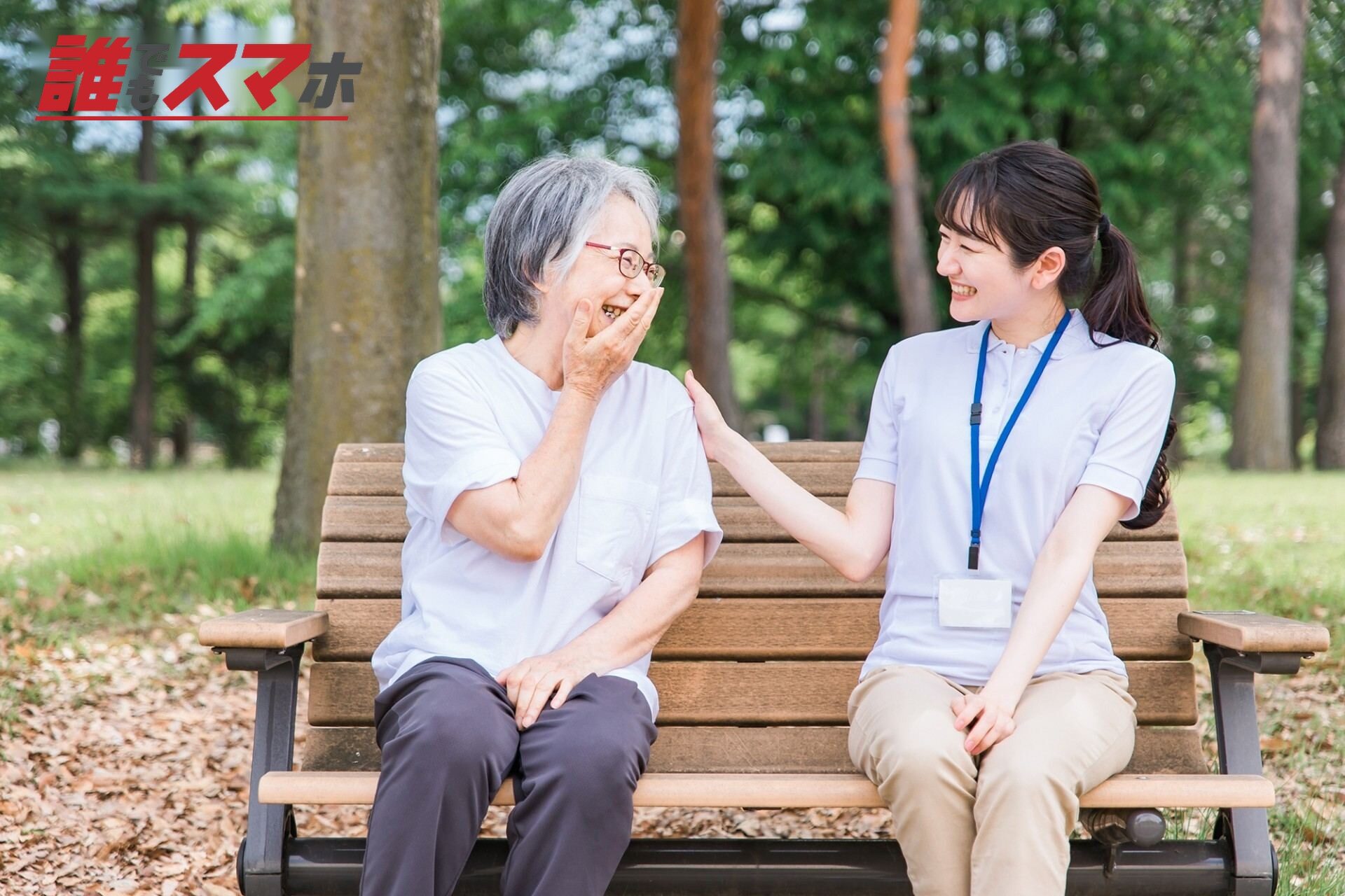 公園で話す高齢者と笑顔の介護スタッフ女性