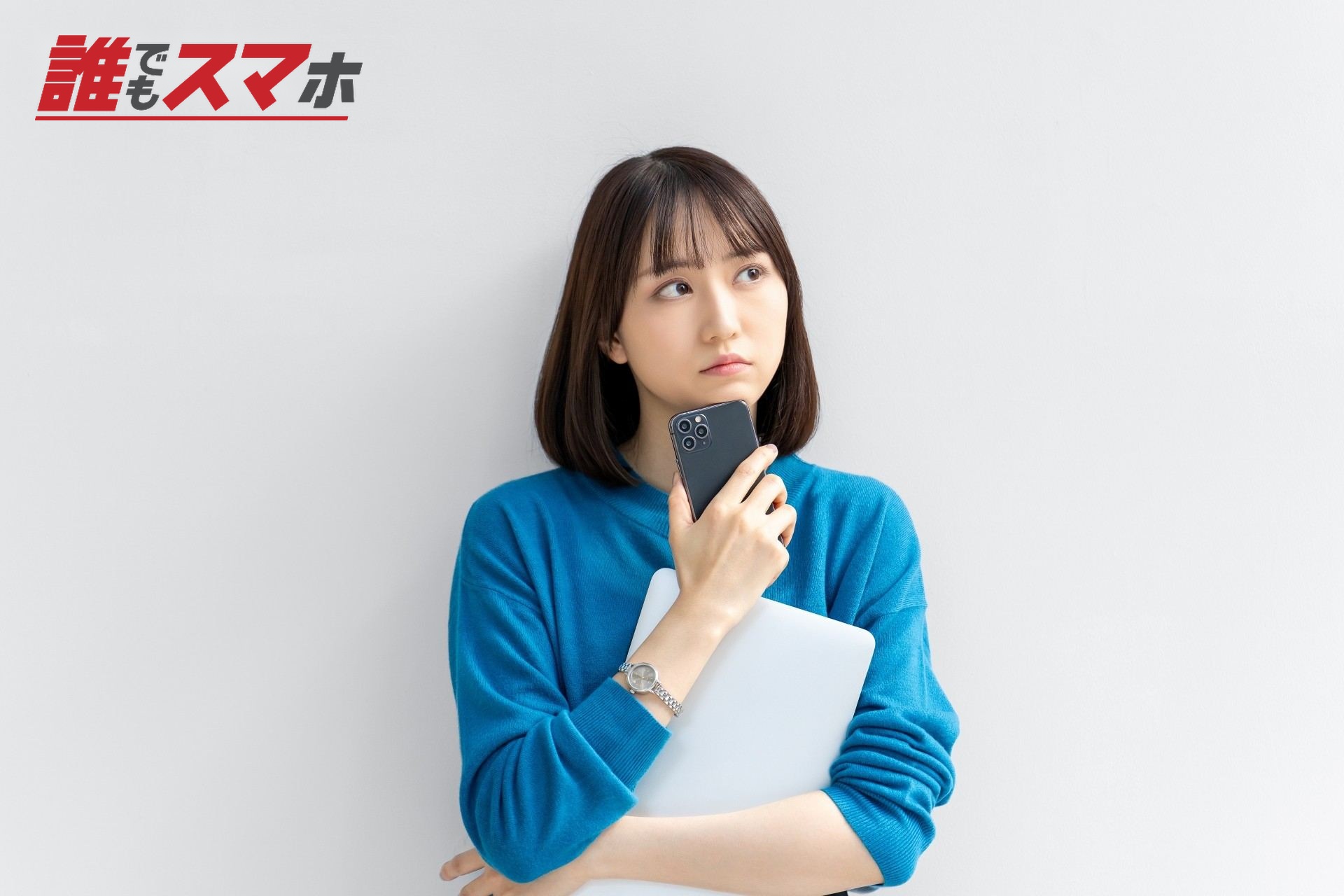 スマホとパソコンを持って考える女性