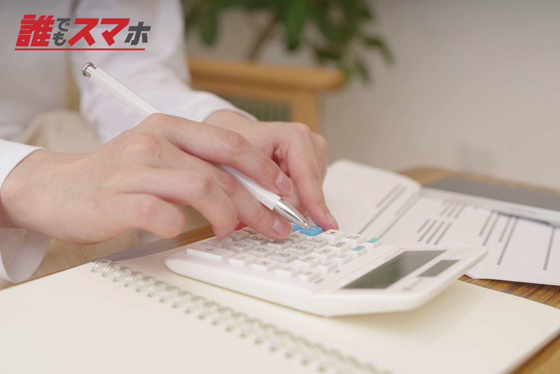 電卓でお金の計算をする女性