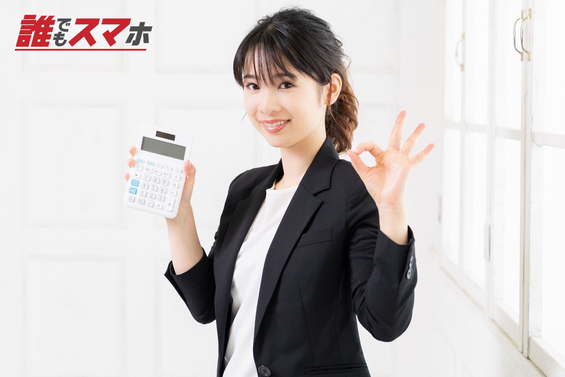電卓を持ってOKサインをする女性