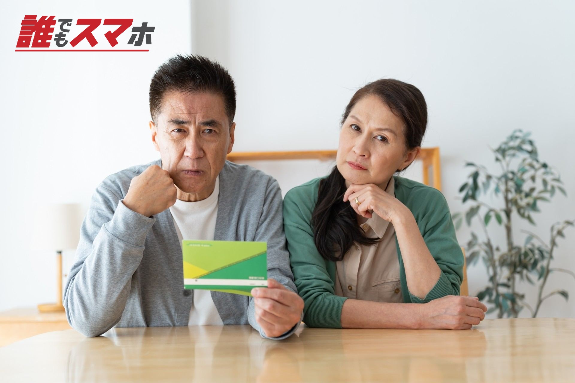 通帳を持ち頭をかしげる夫婦