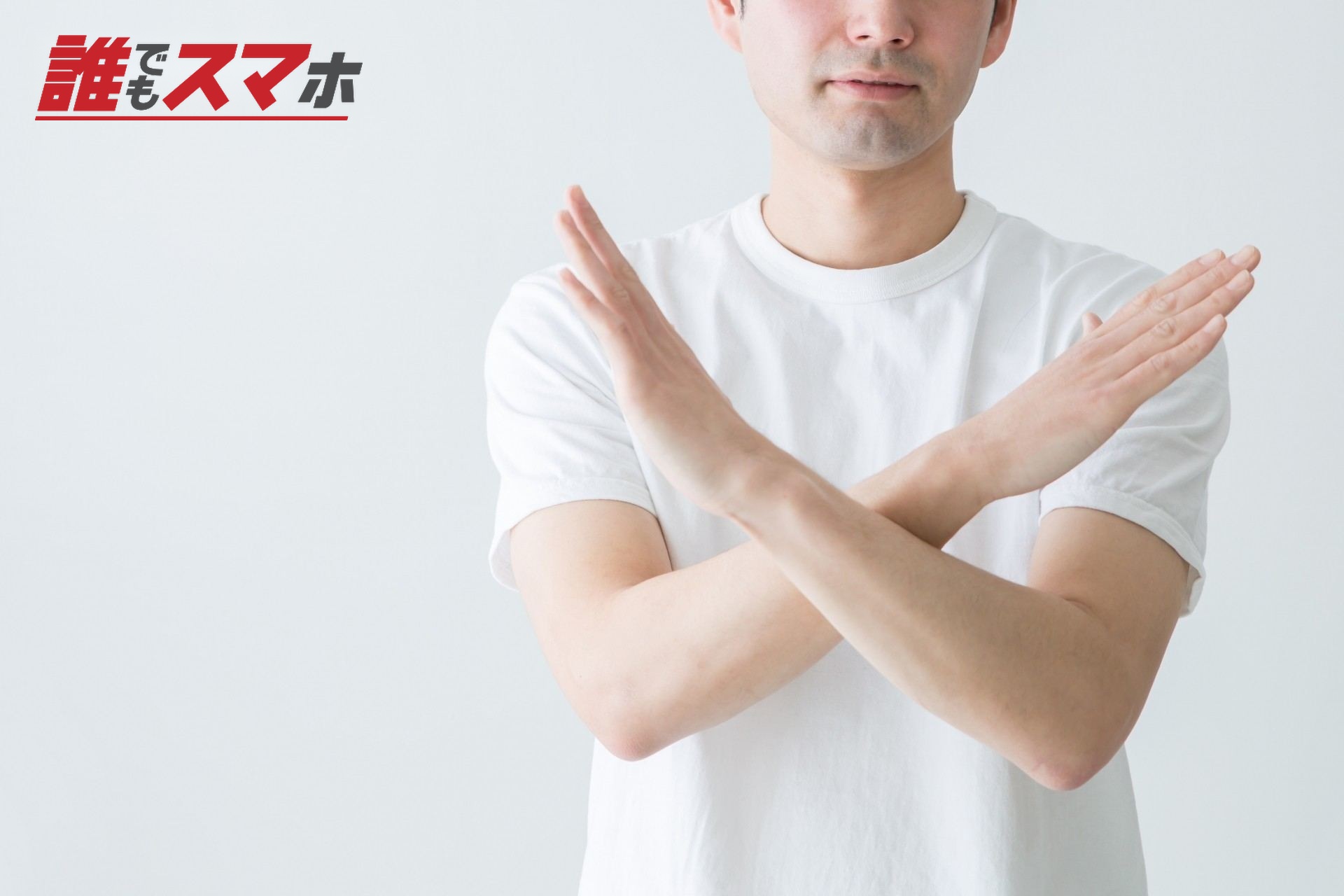 両手でバツマークをする男性
