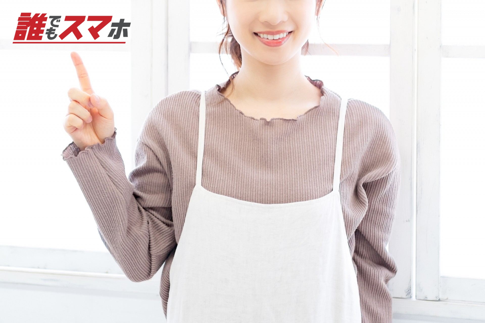 指を立てて案内する女性