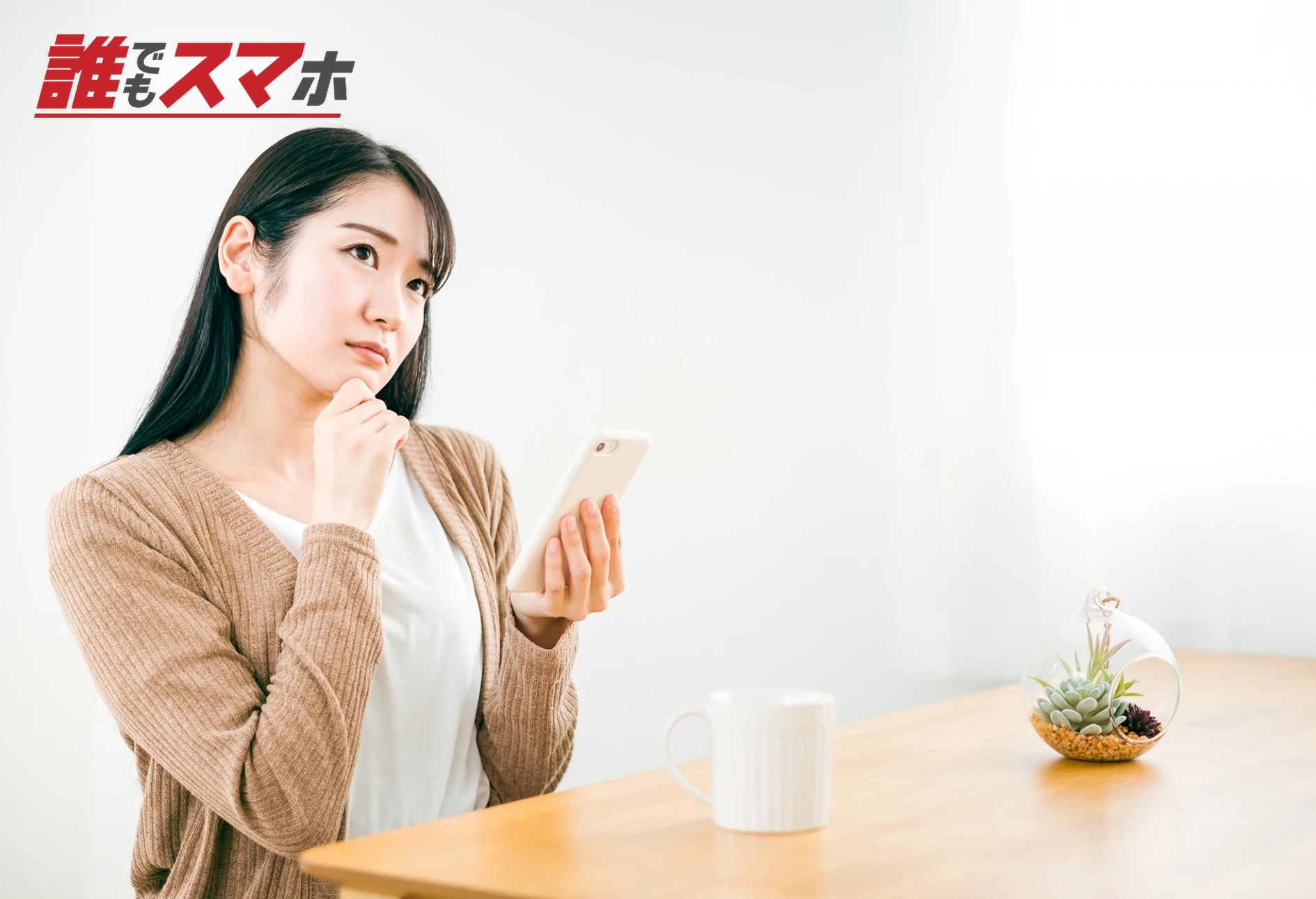 家でスマホのアプリを使いながら考える女性