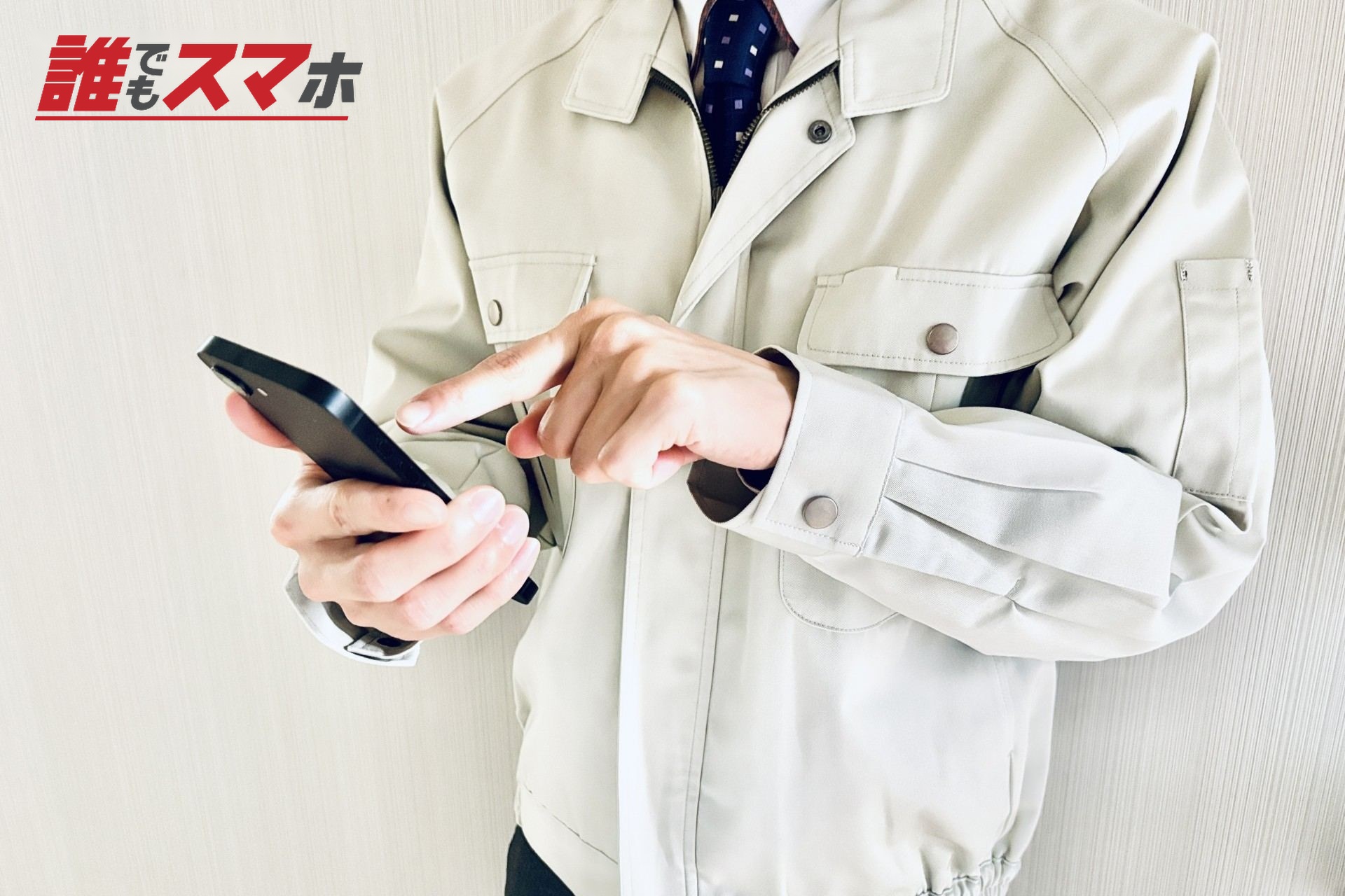 スマホを使用する作業着の男性