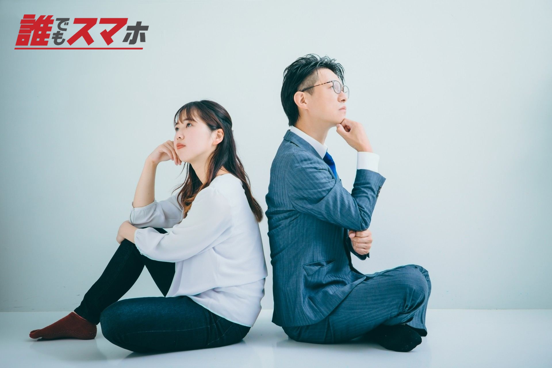 背中合わせに座る男女