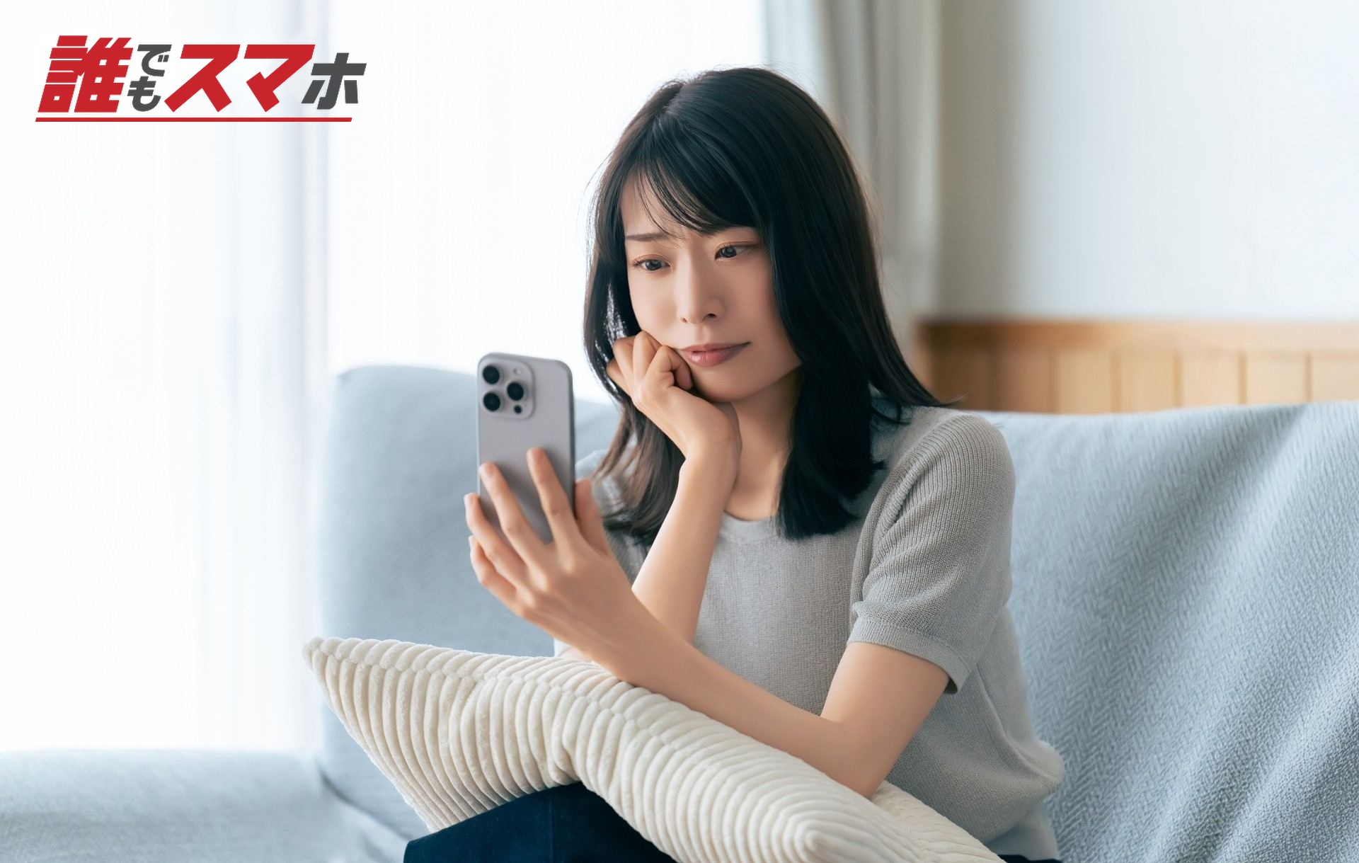 携帯電話を見て悩む女性