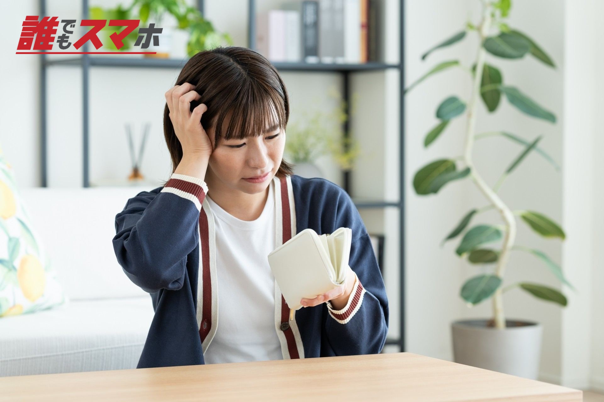 悲しそうに財布の中を見る女性