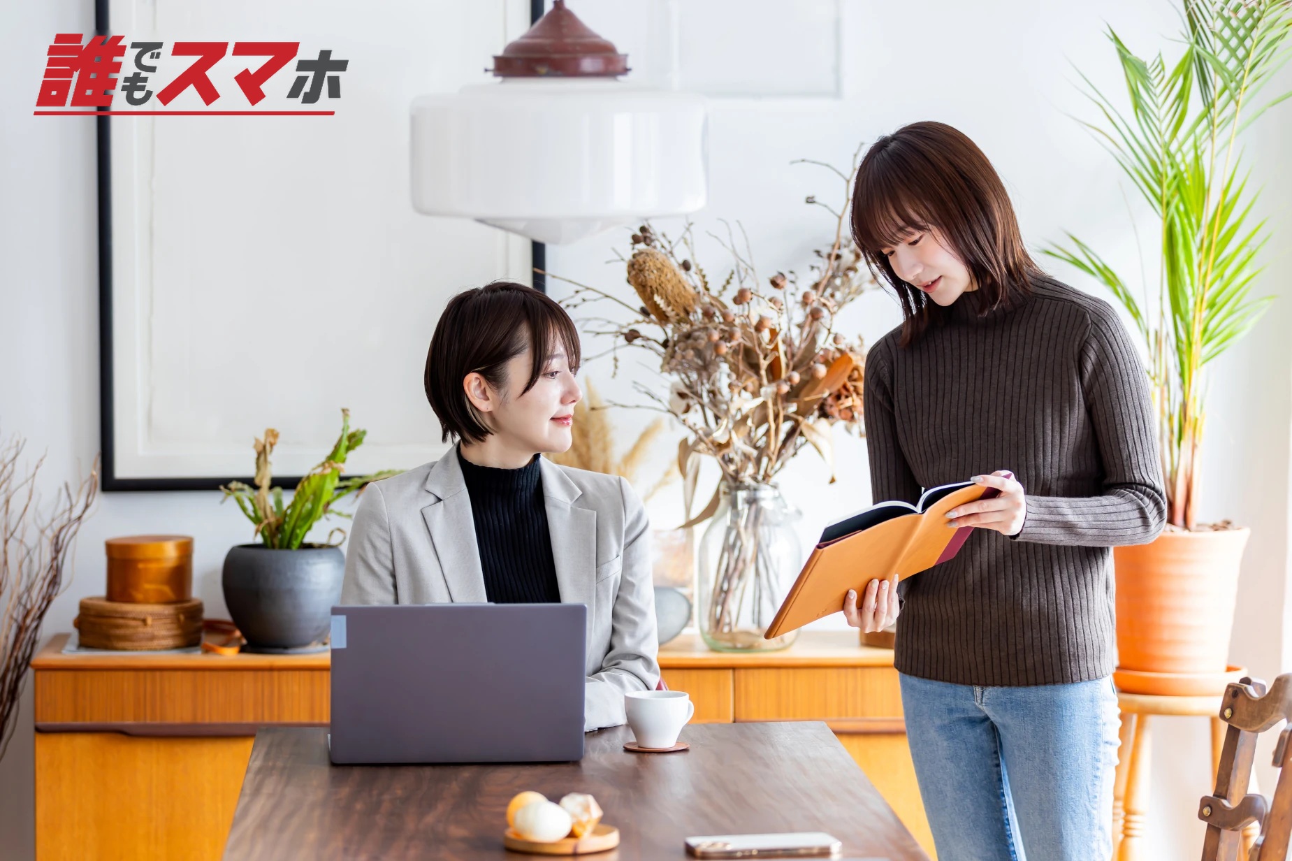 本を見て話し合う女性2人