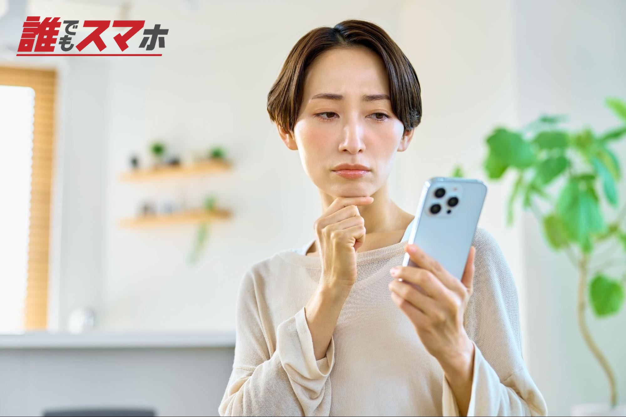 携帯電話を見て悩む女性