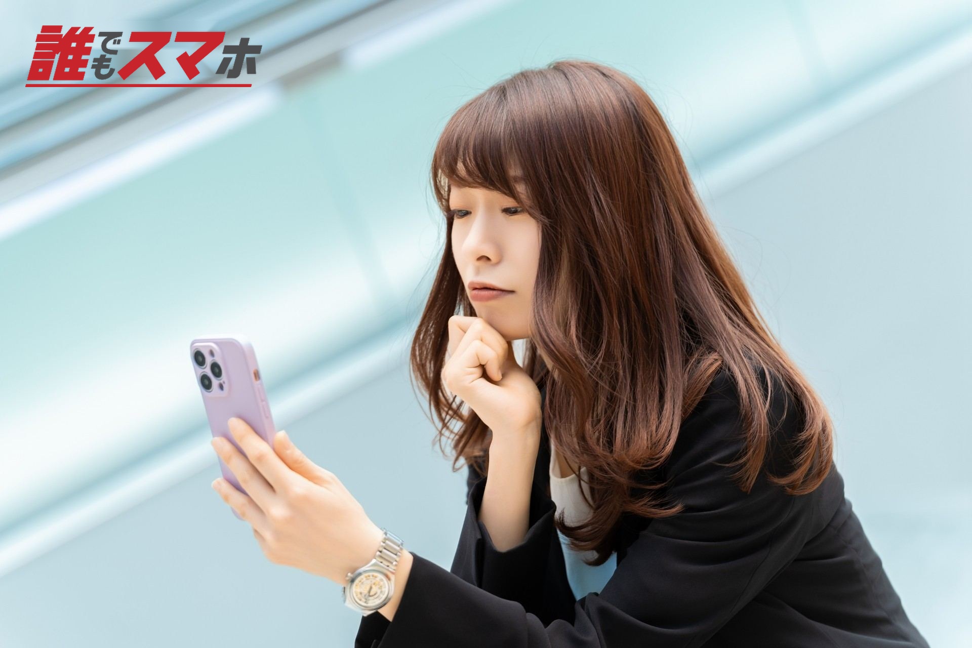 携帯電話を見て悩む女性