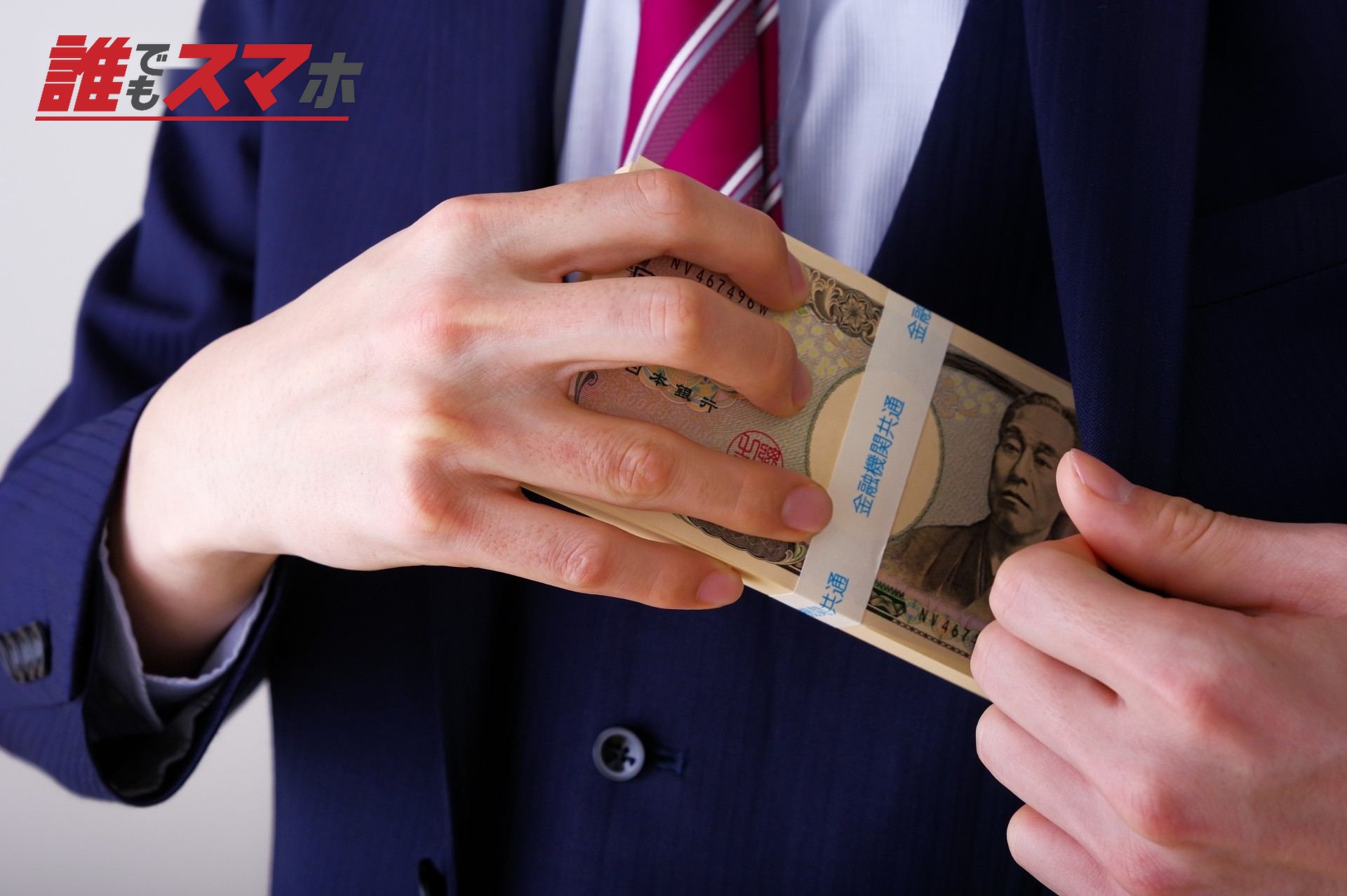 大金を手に持つスーツ姿の男性