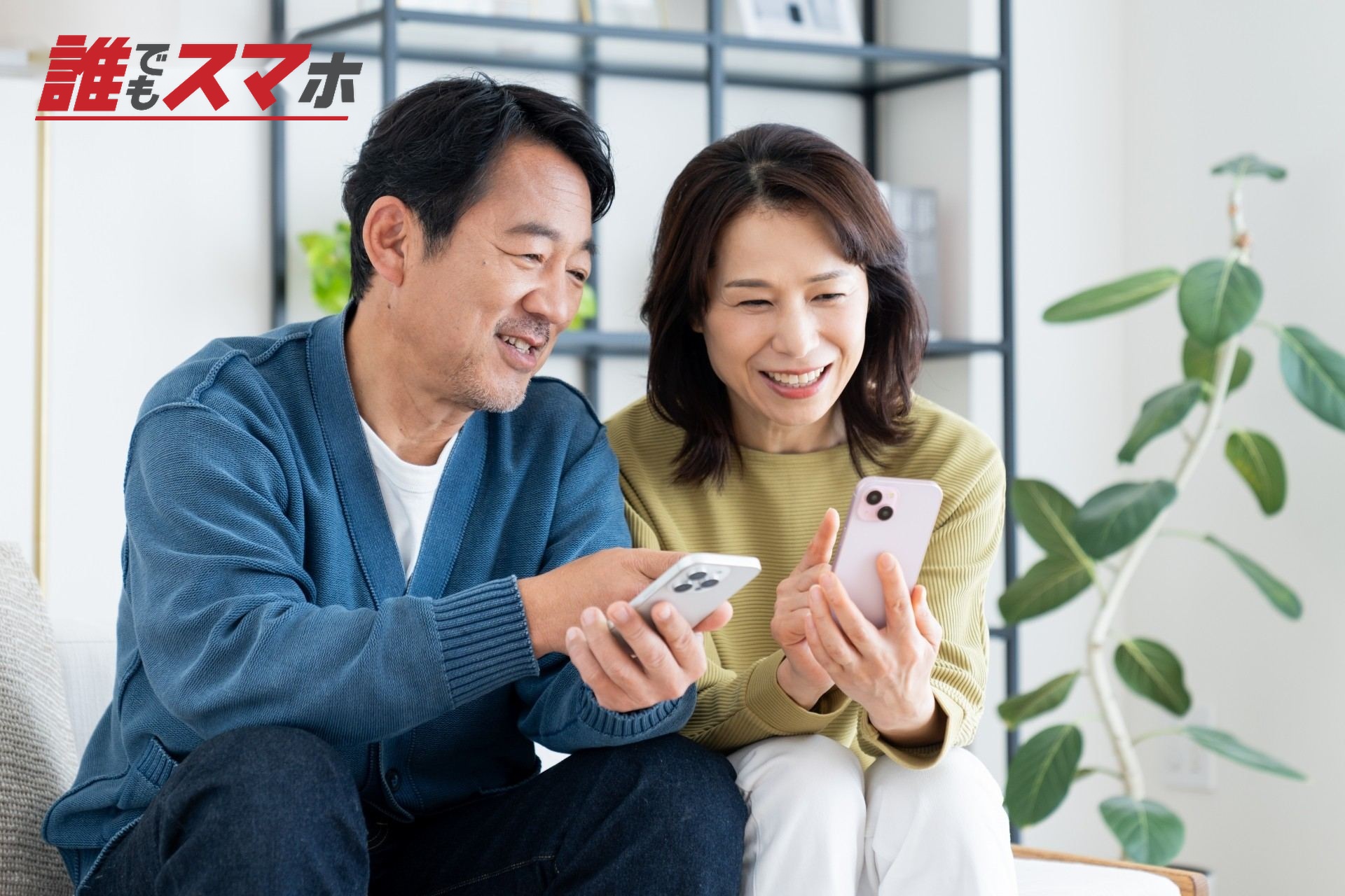 笑顔でスマホを見せ合う男女