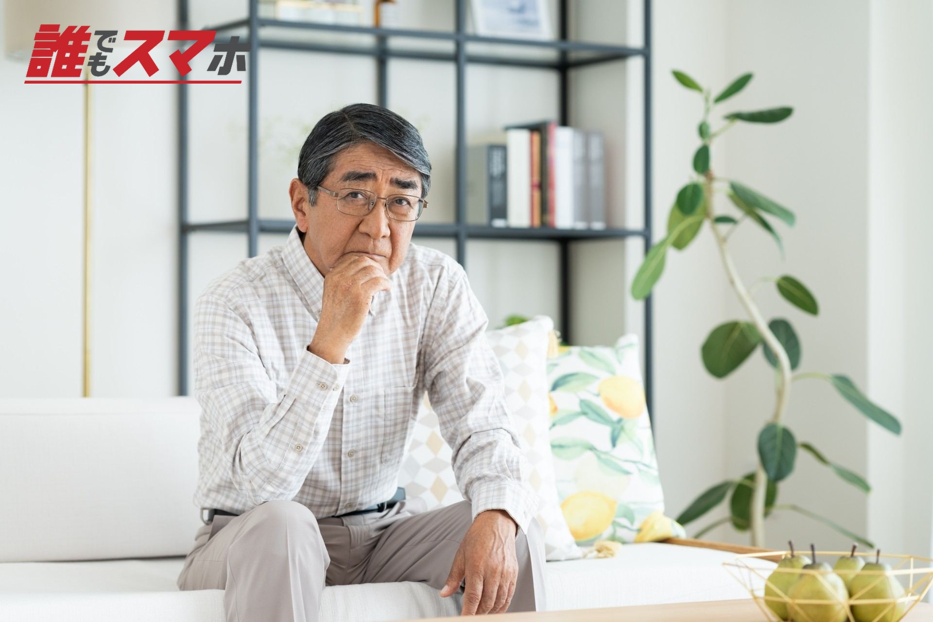 ソファに座り考える男性