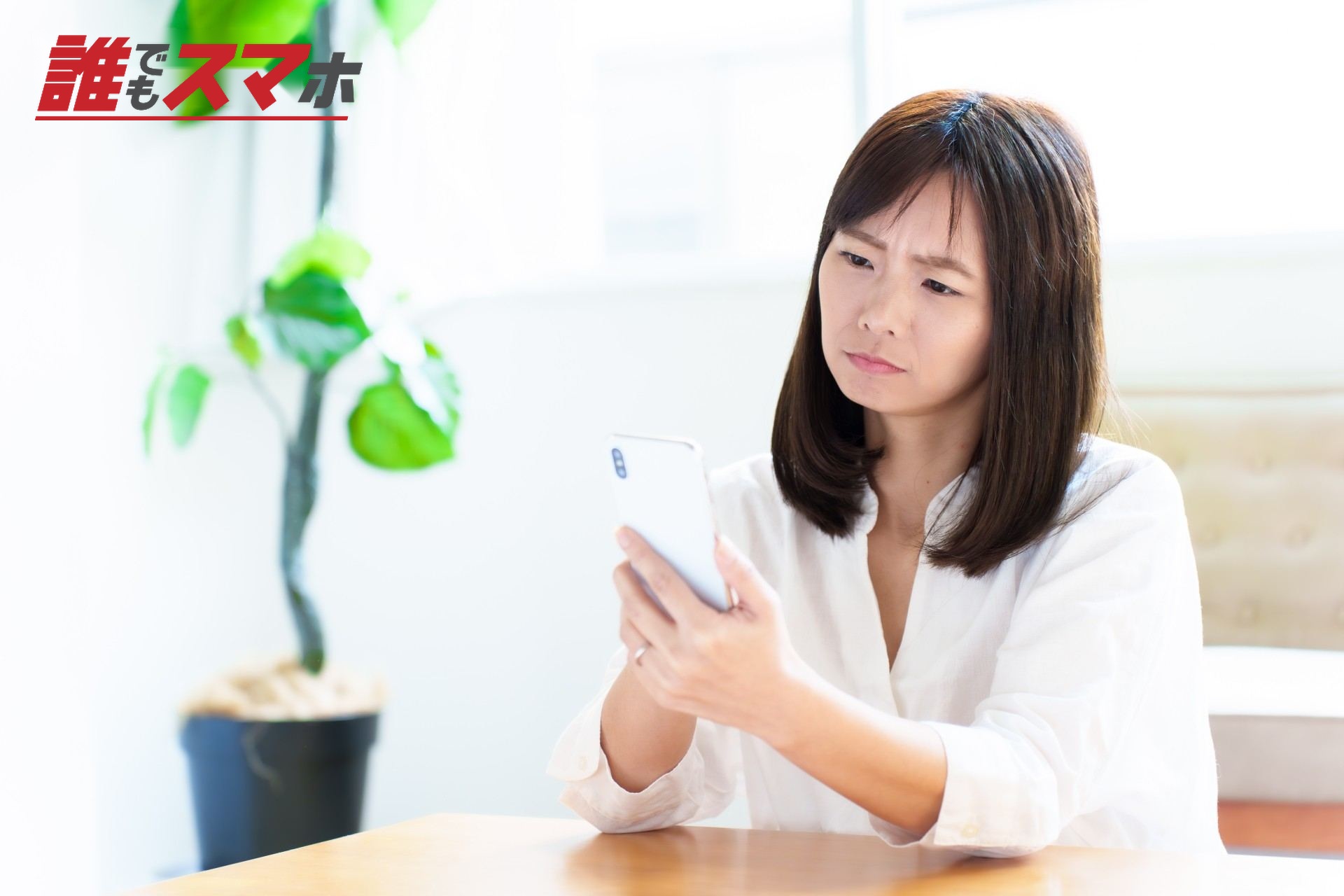 辛そうにスマホを見る女性