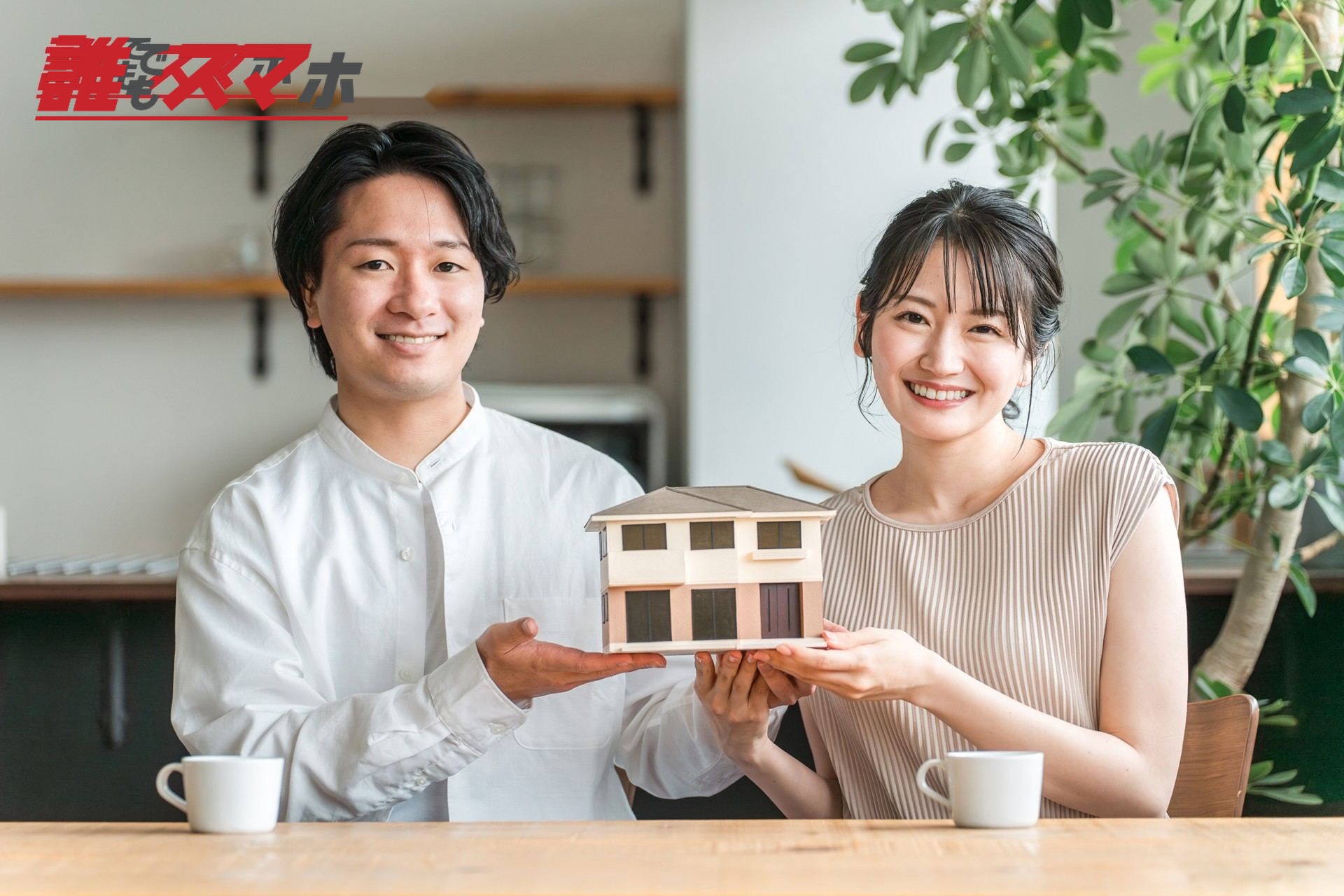 住宅模型を持ち微笑む男女