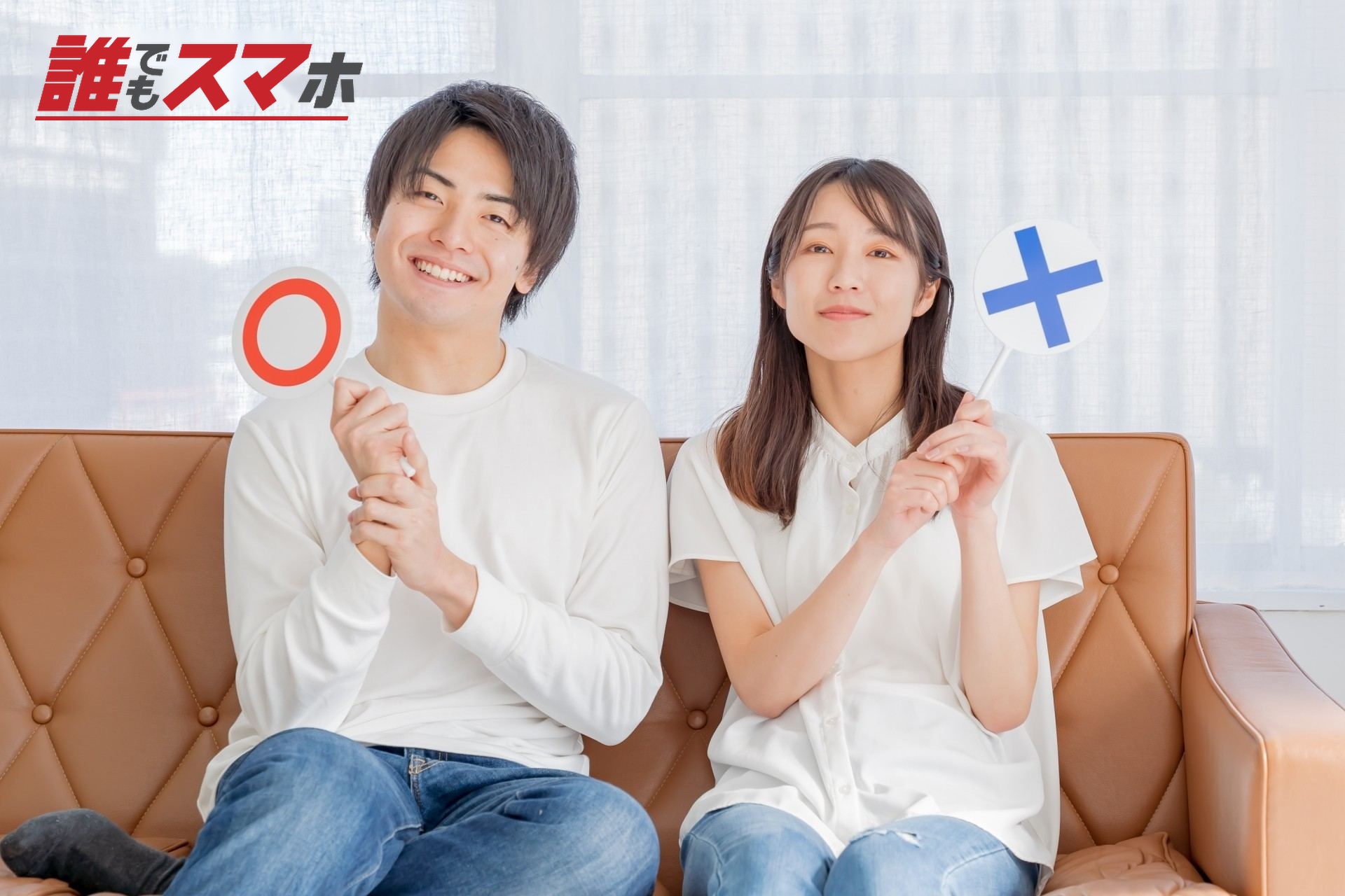 丸とバツの札を持つ男女