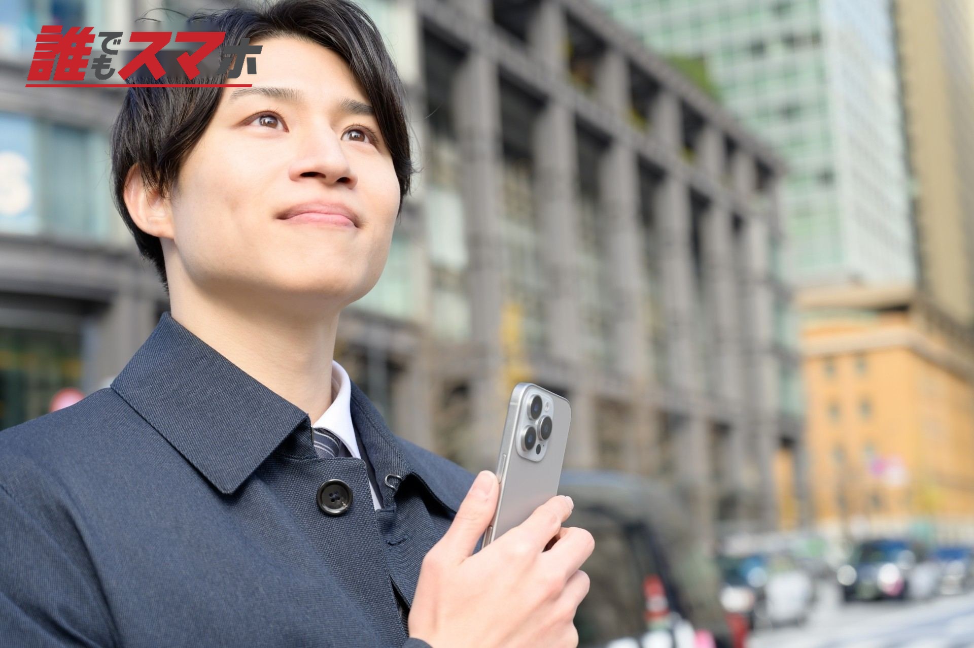 スマホをもち微笑む男性