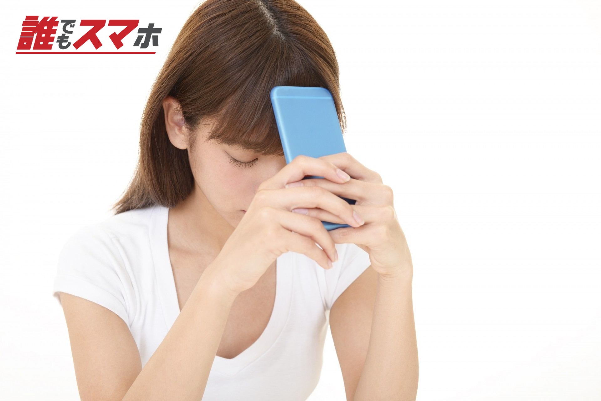 スマホを額に当てて悩む女性