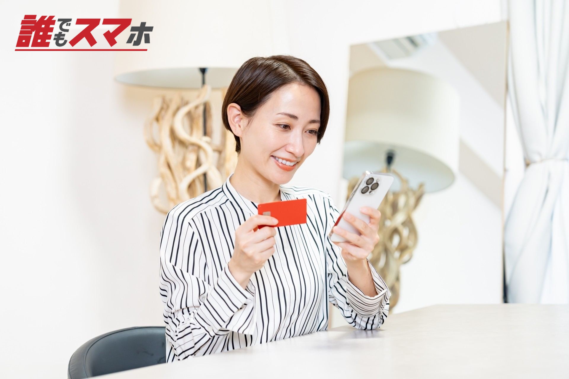 携帯電話とクレジットカードを見る女性