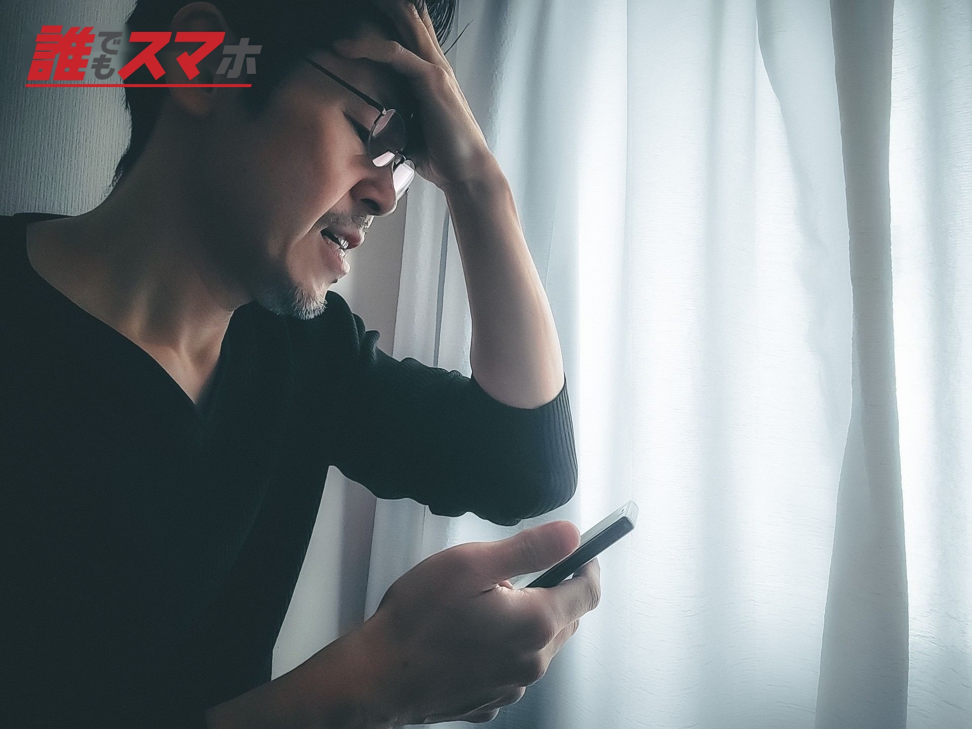 スマホをみて焦る男性
