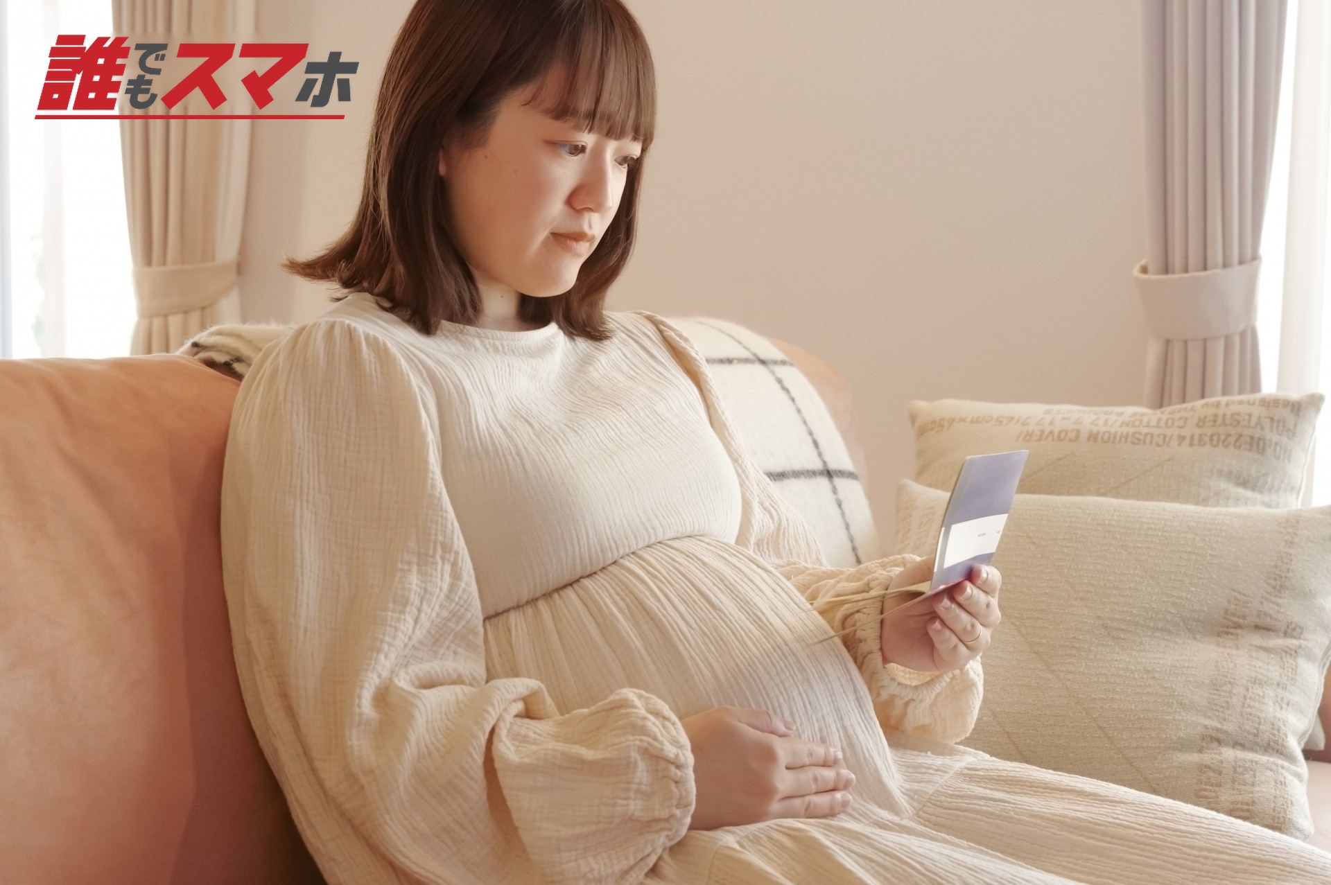 通帳を見る妊婦