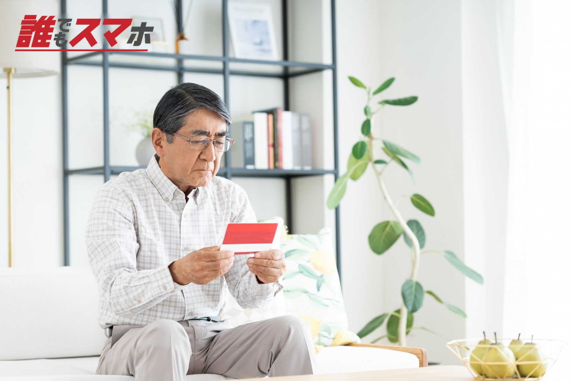 通帳を見つめる男性