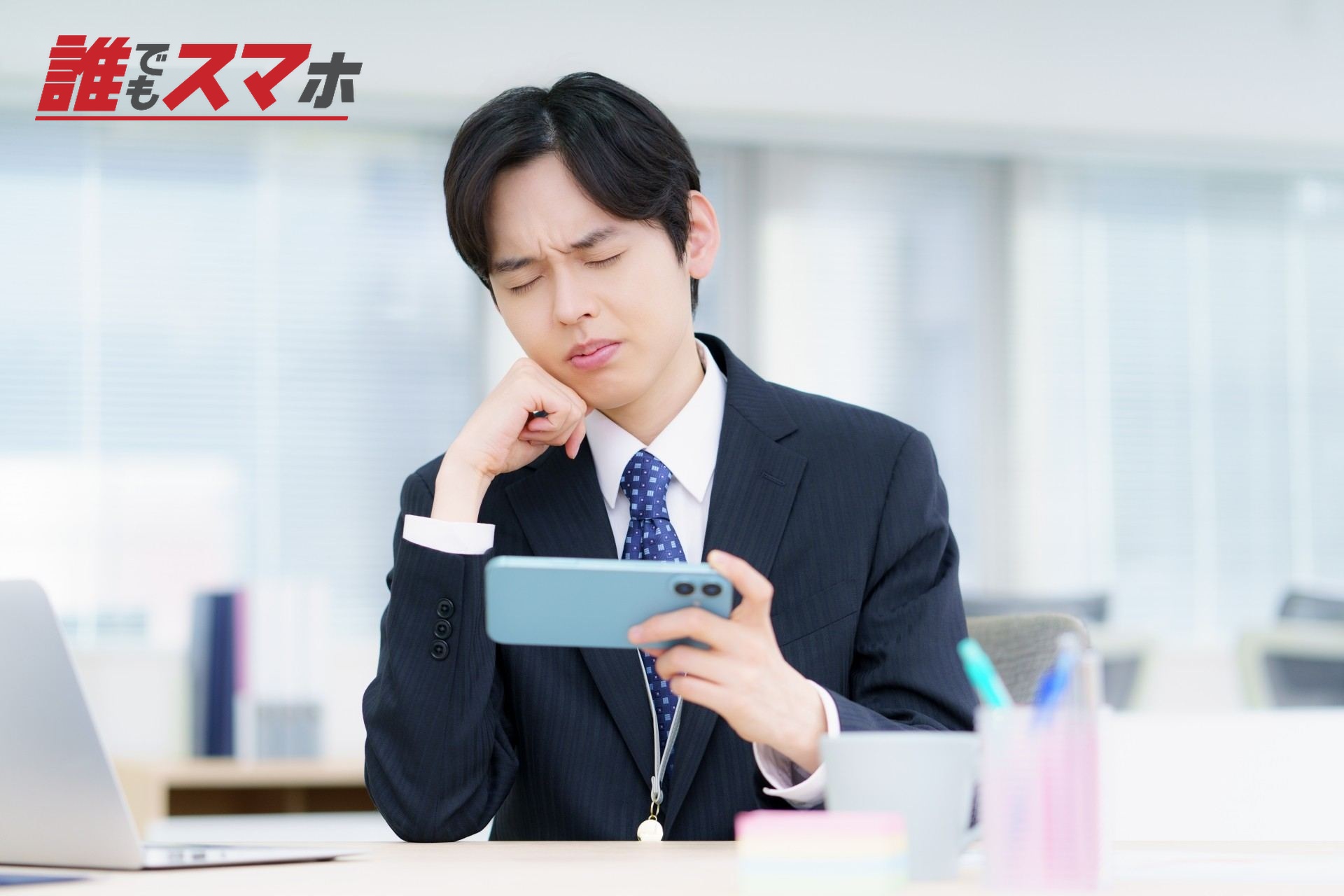 スマホを手に悩む男性