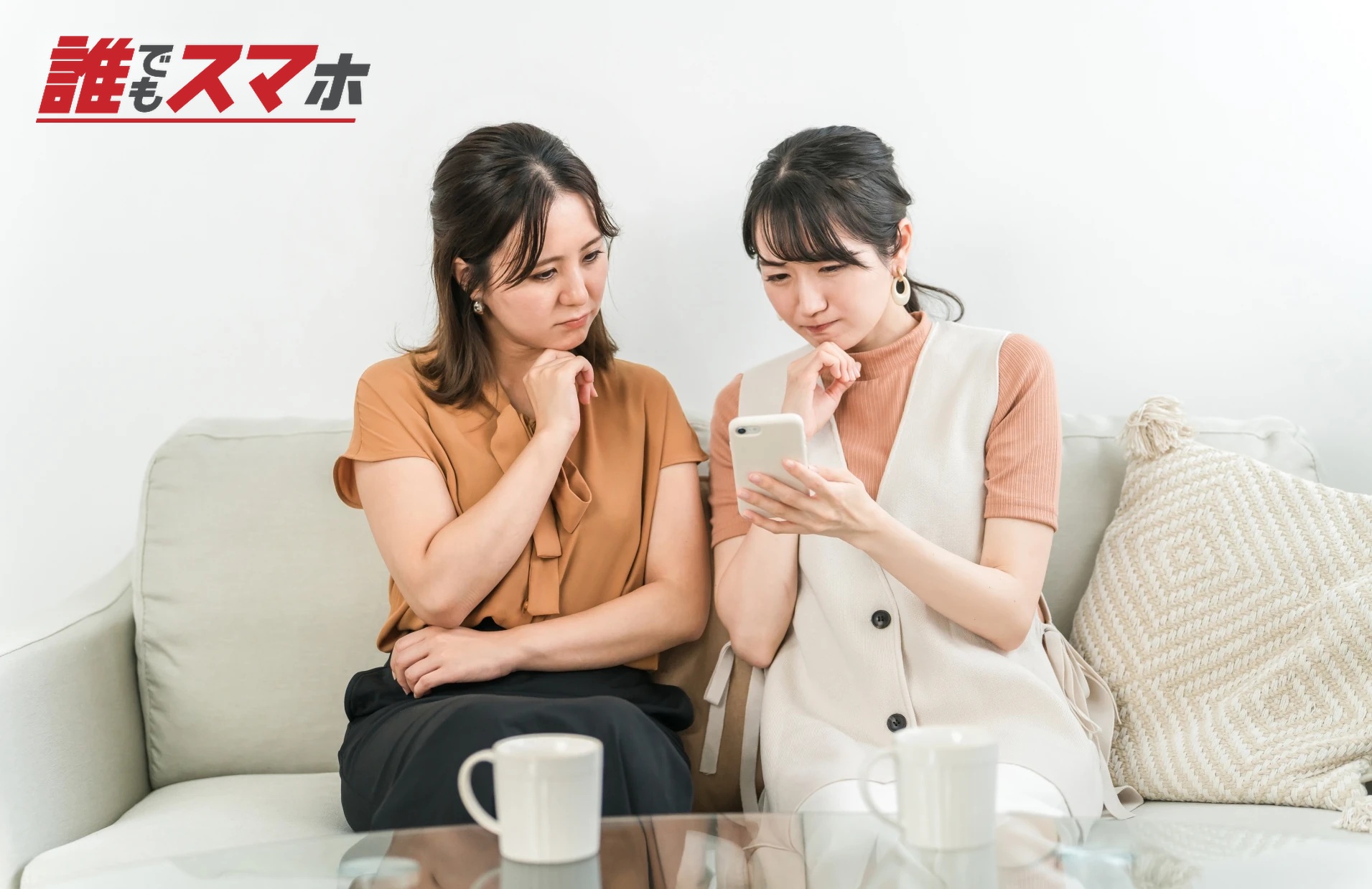スマホを見て考え込む女性2人