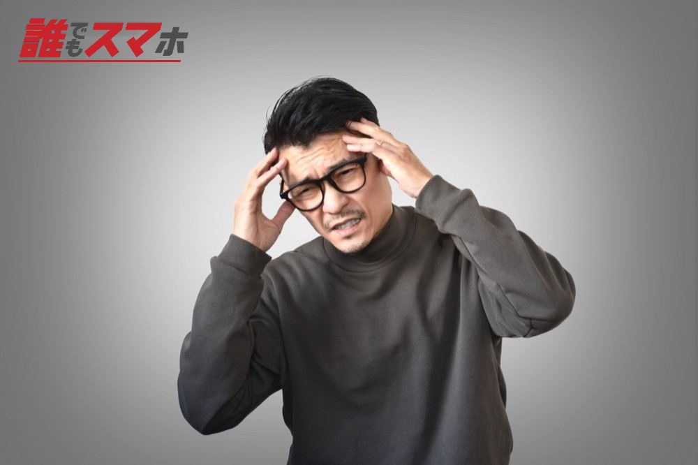 頭を抱えて悩む男性
