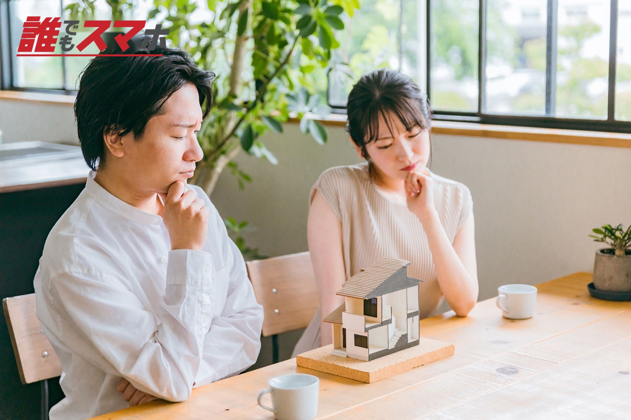 住宅模型を見て間取りを検討する夫婦