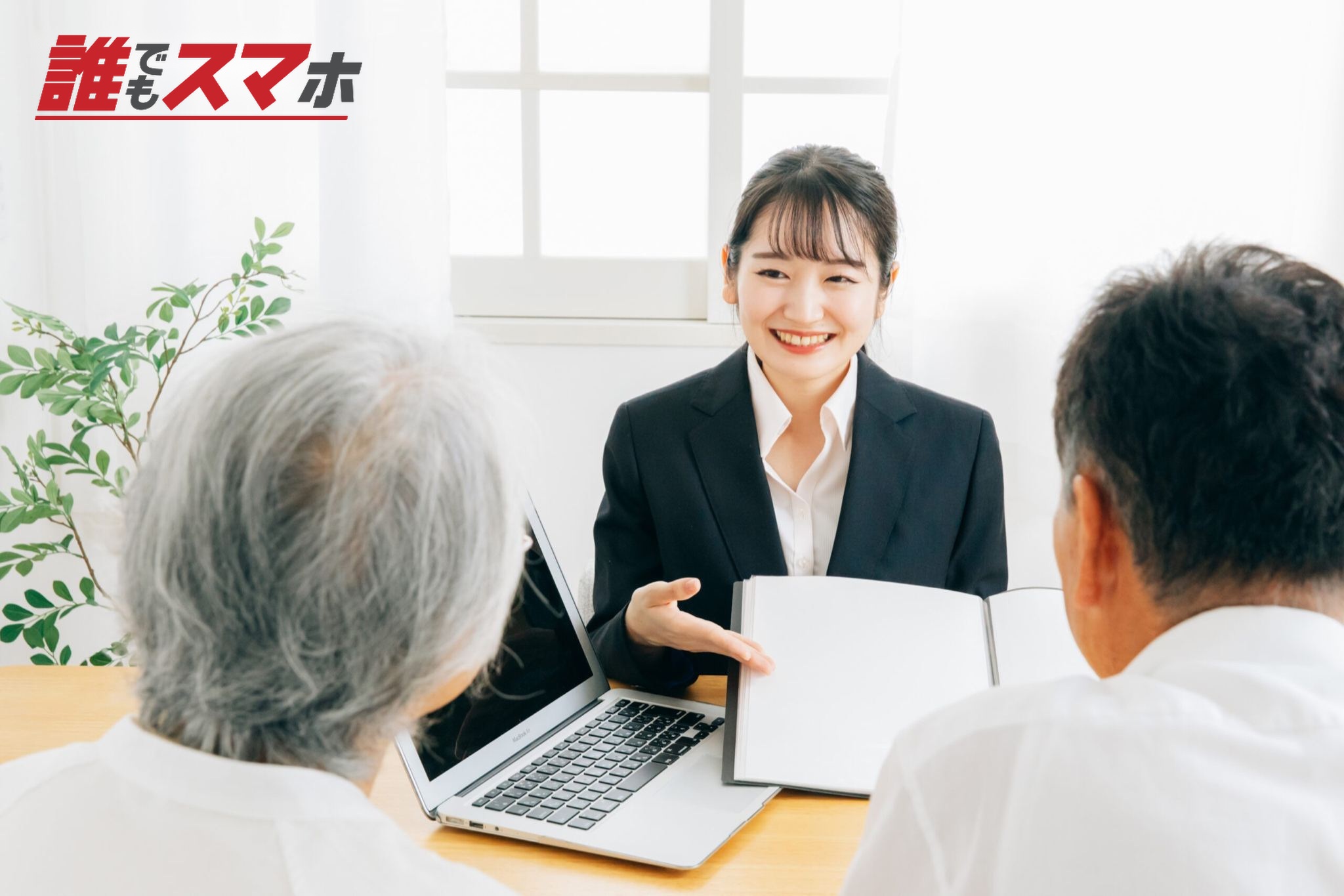 資料で説明する女性と高齢者夫婦