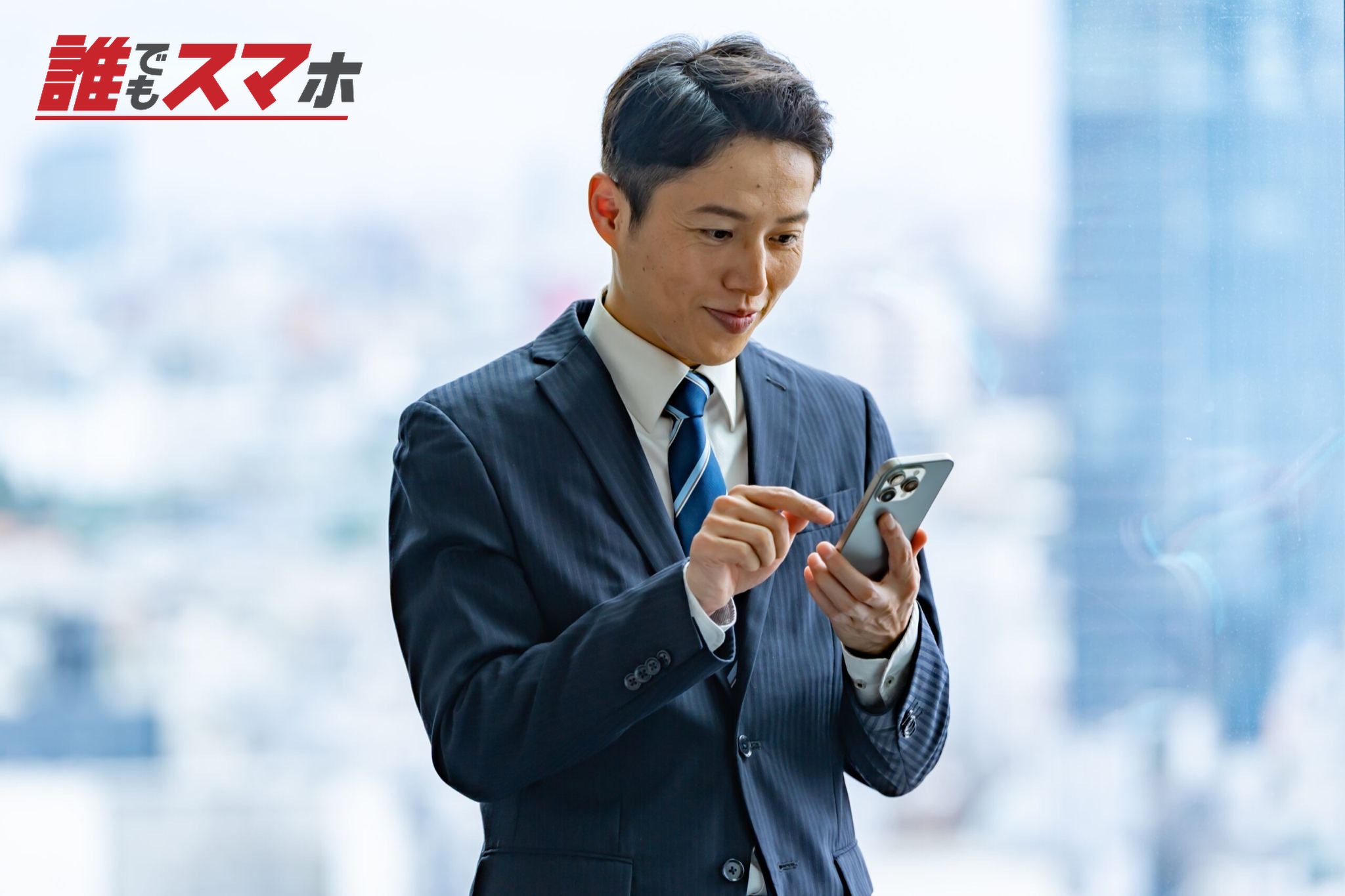高層ビルで携帯を触るビジネスマン
