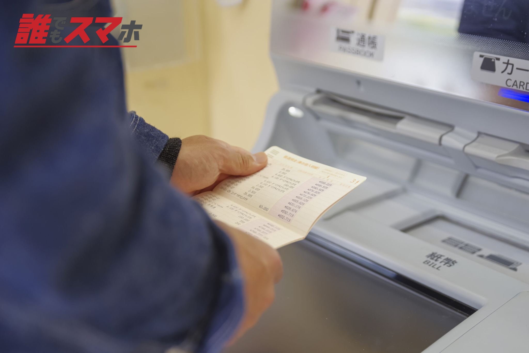 銀行ATMで通帳記帳を行う利用者