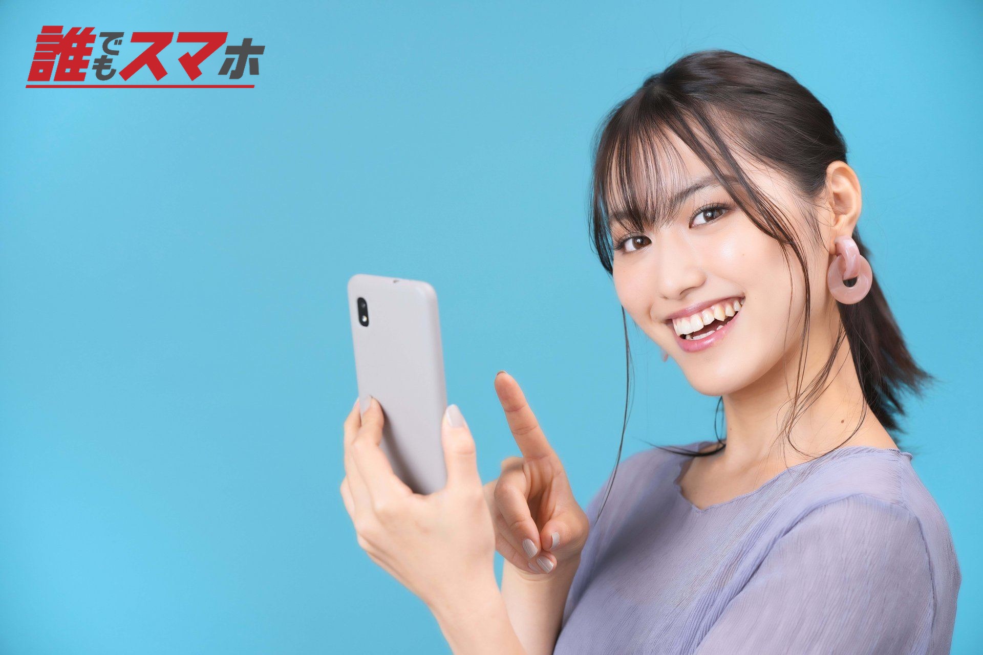 スマホを持つカメラ目線の女性