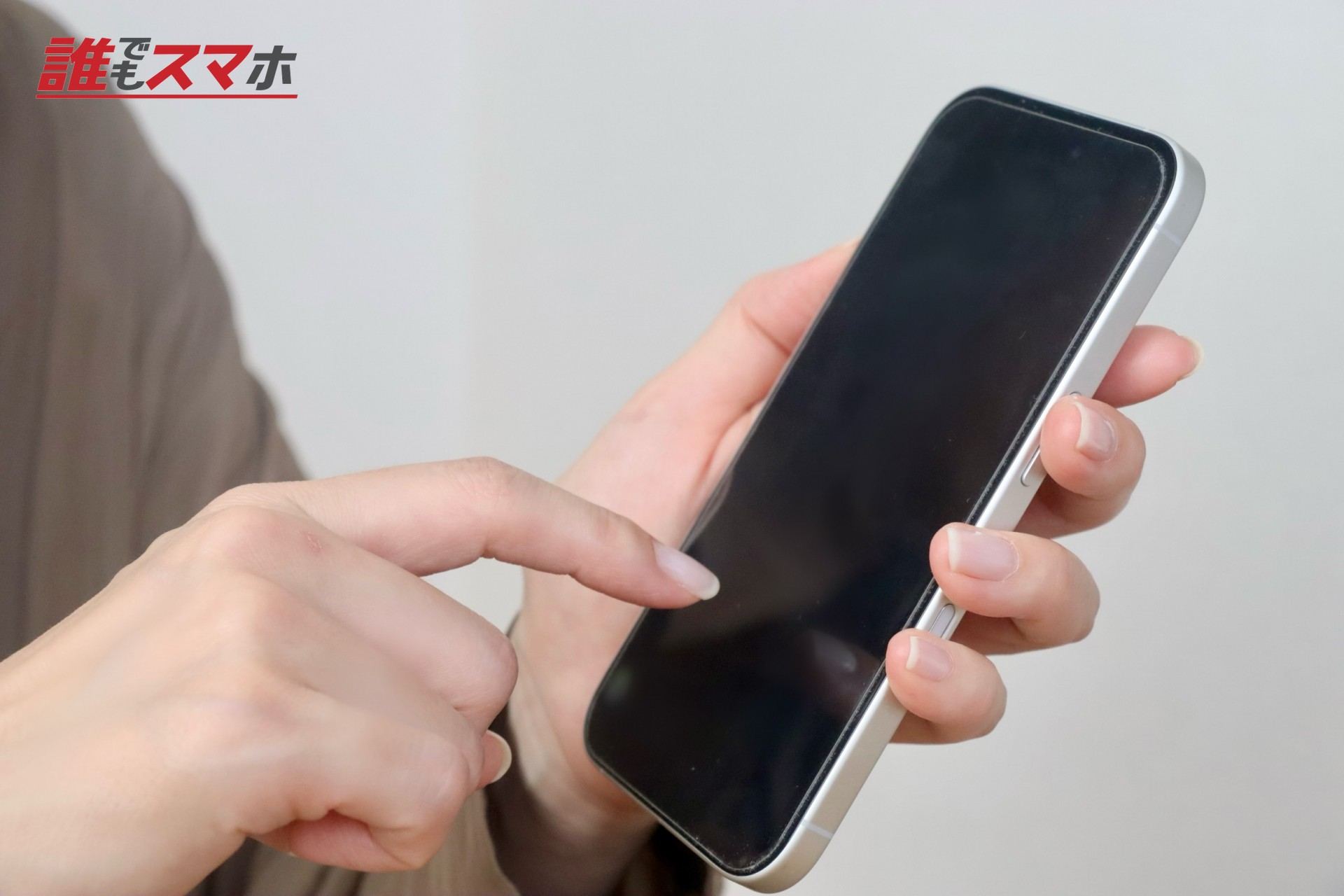 スマホを指さす女性