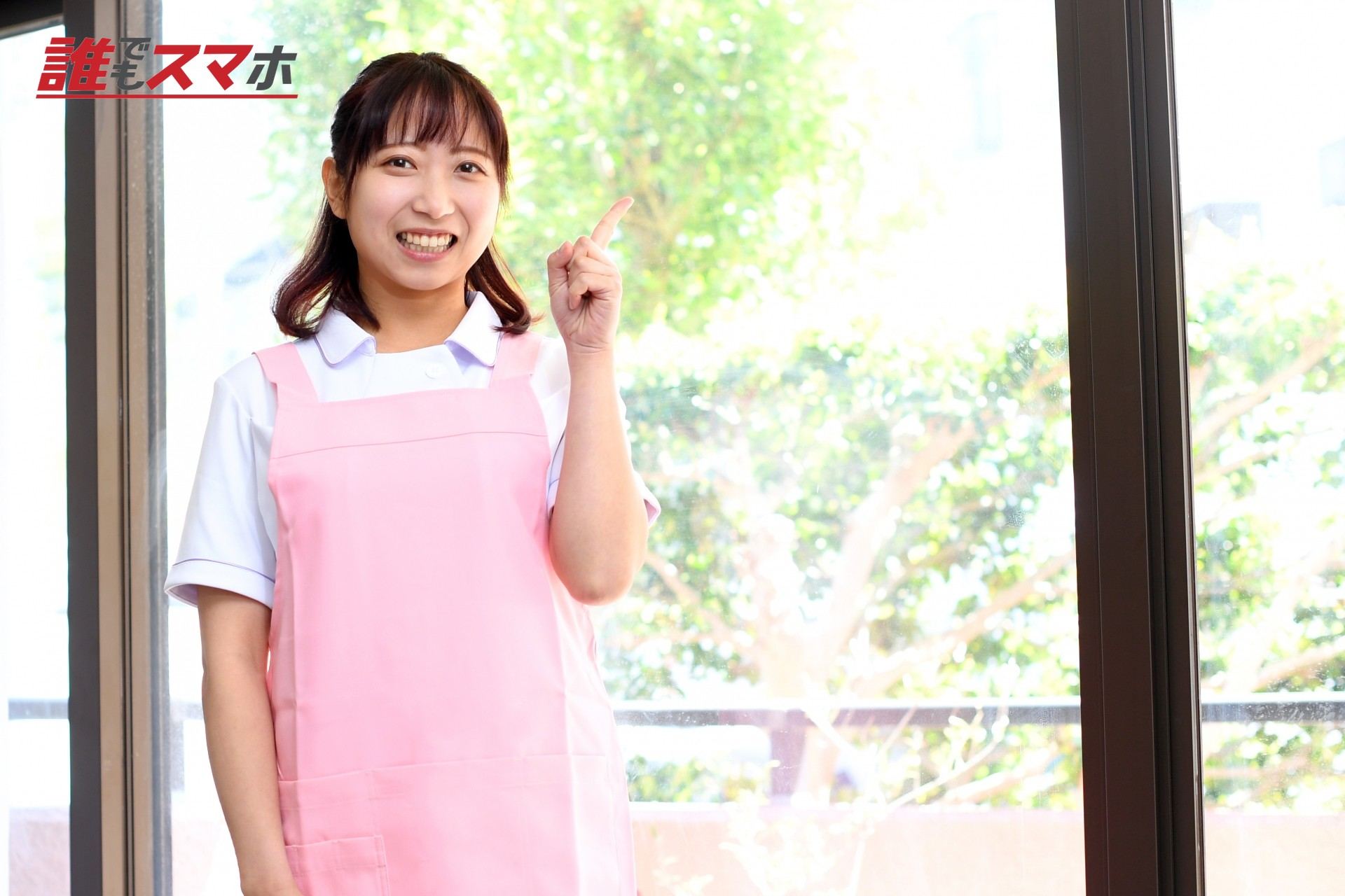 指差しをするエプロン姿の若い女性