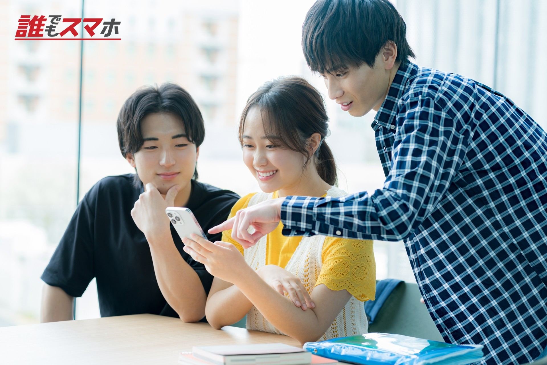 スマホを見ながら話す学生たち