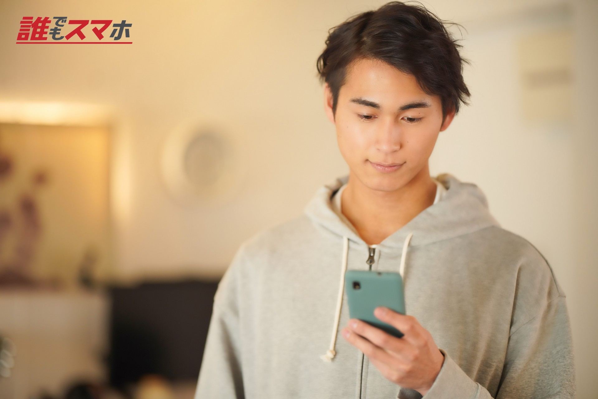 立ってスマホを使う男性2