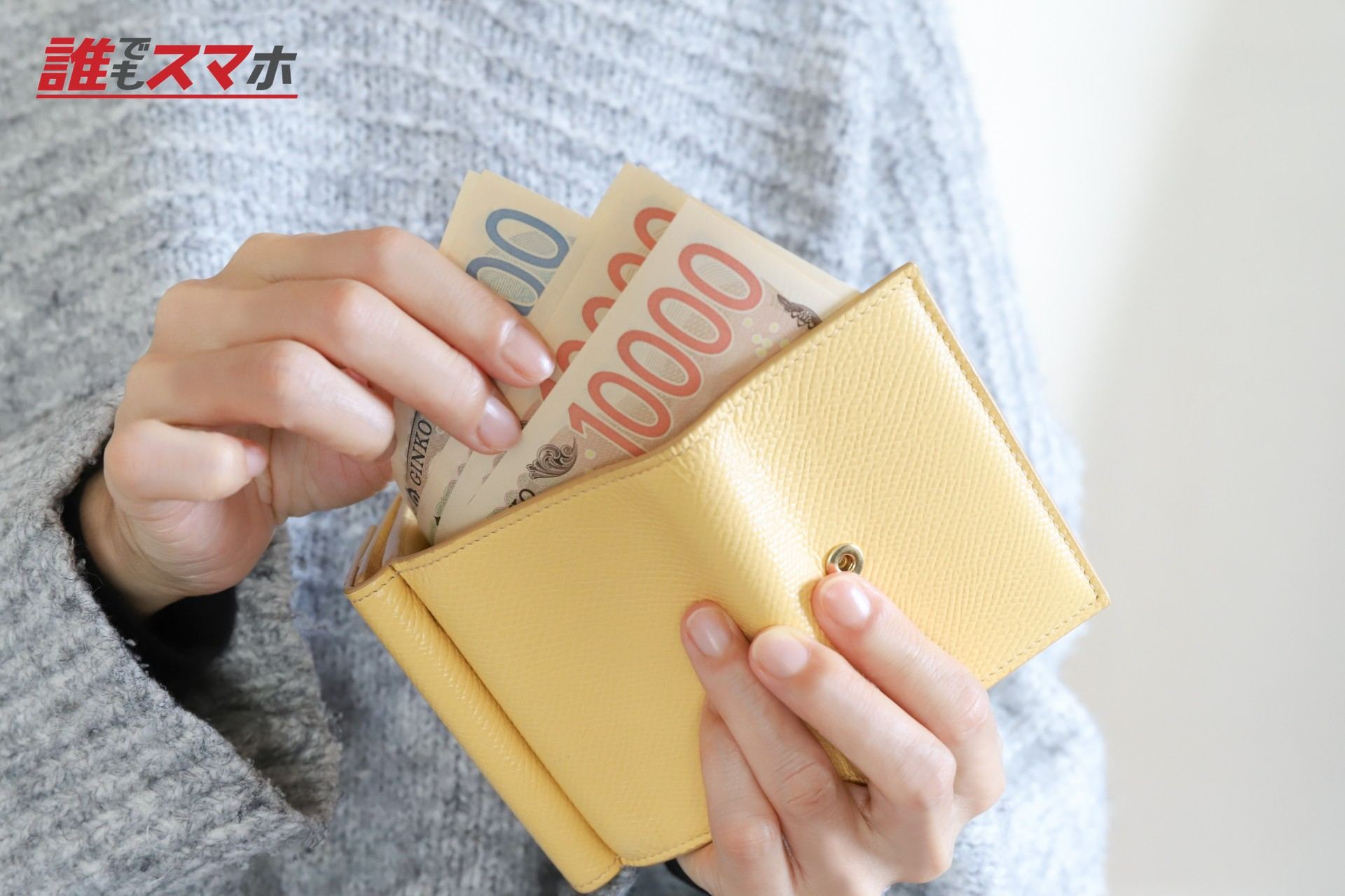 財布からお金を出す主婦