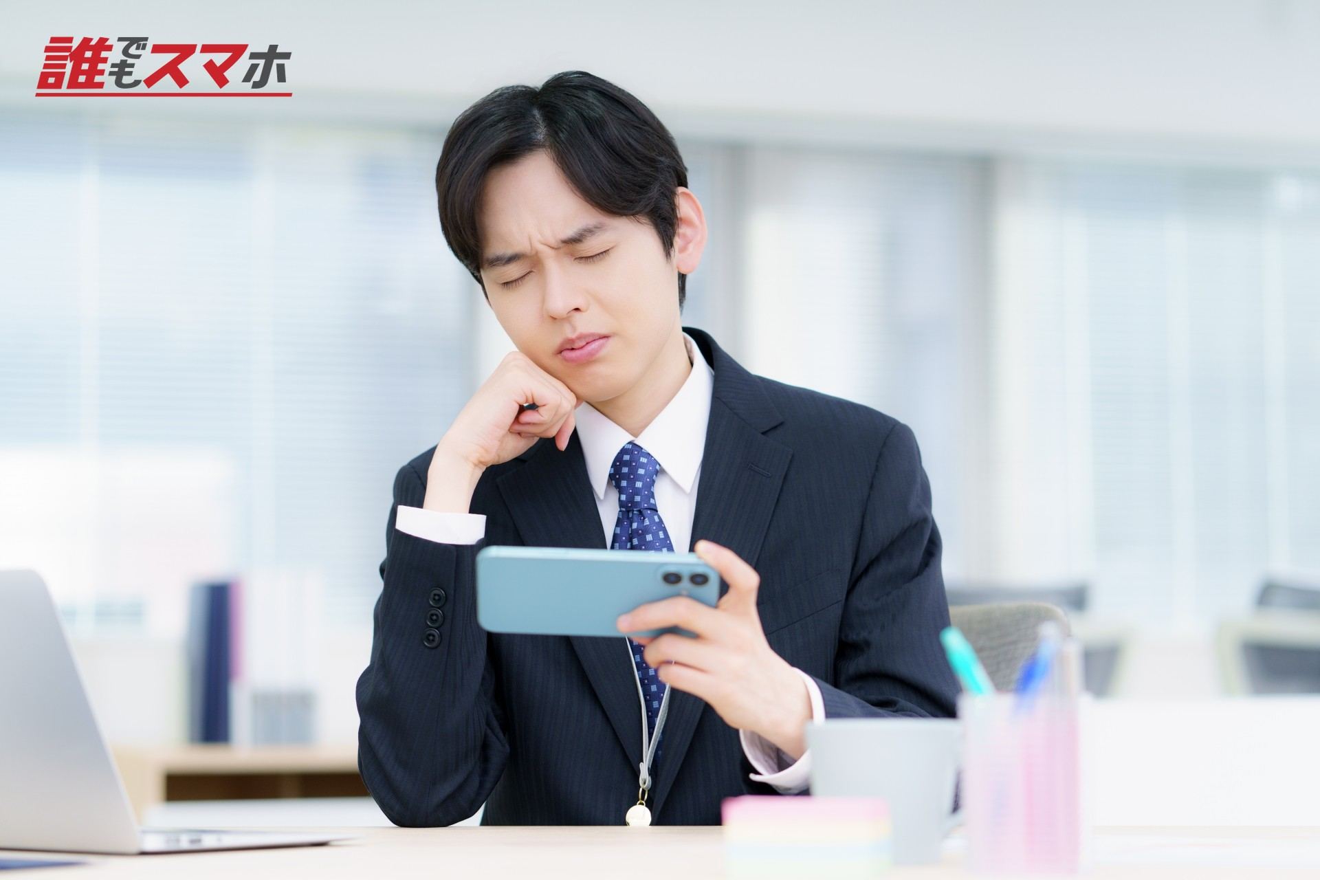 スマホを手に悩む男性
