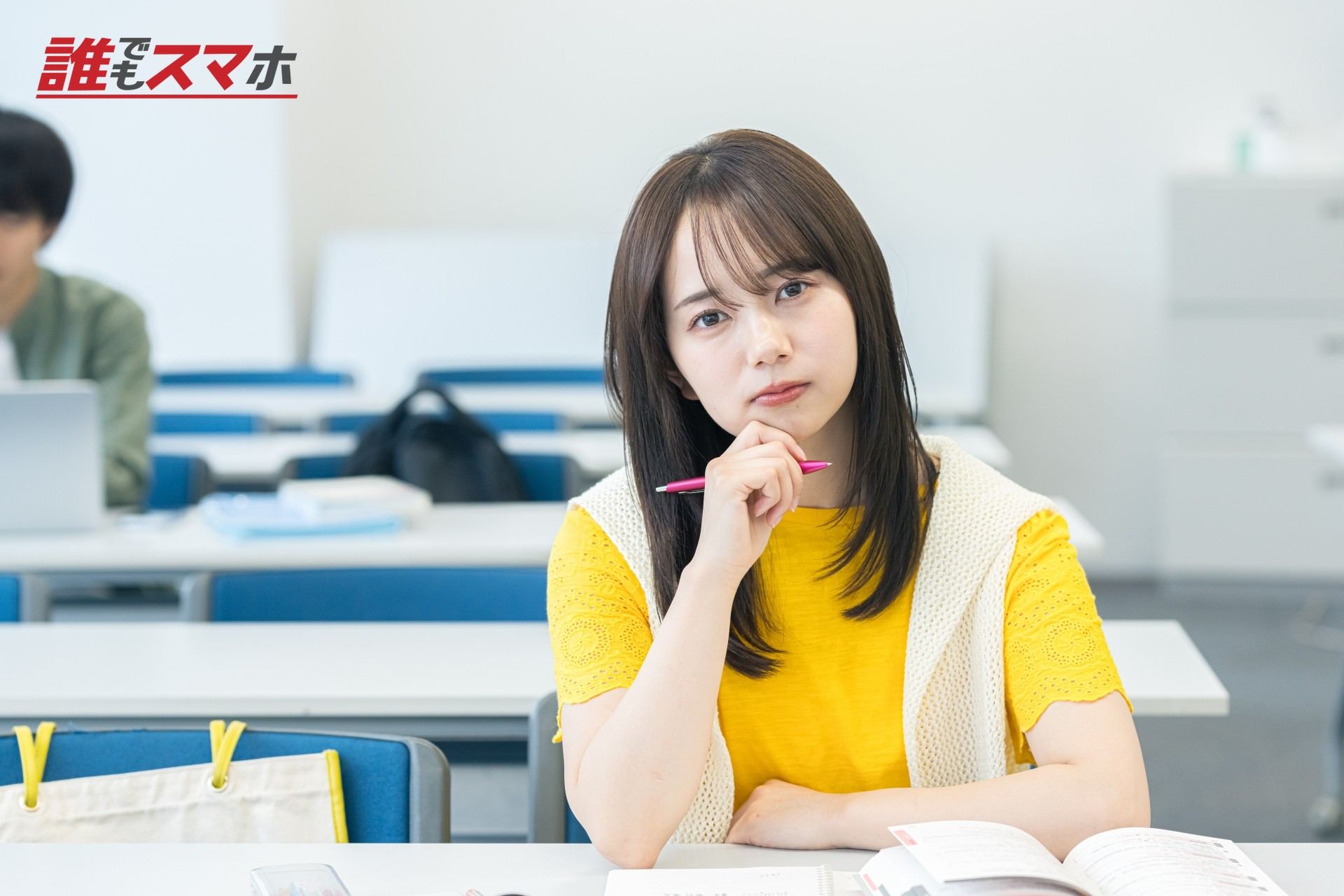 ペンを持ちながら悩む女性