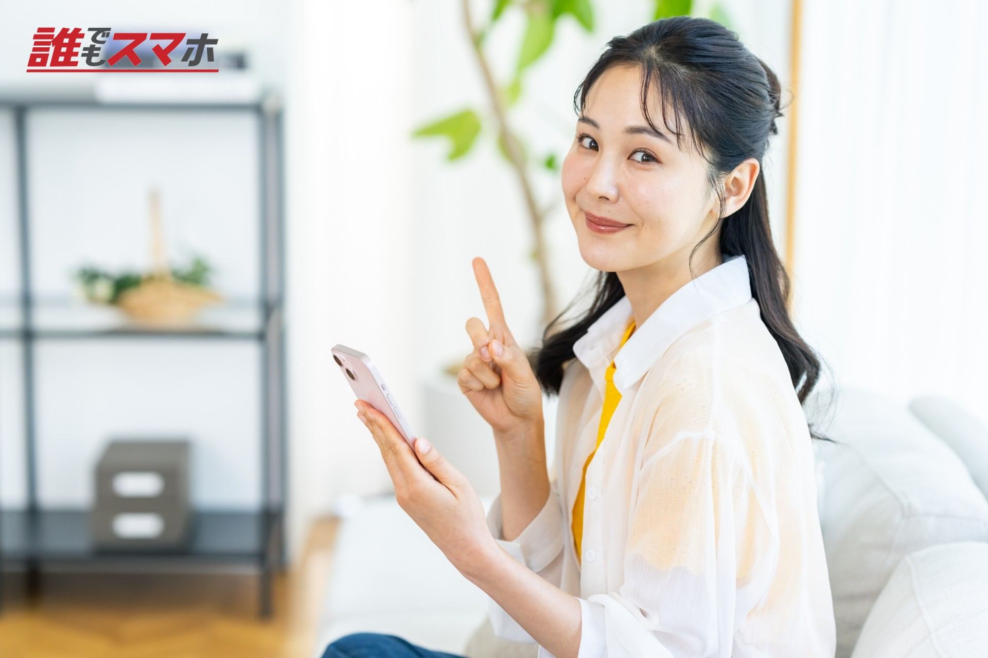 部屋でスマホを操作する女性