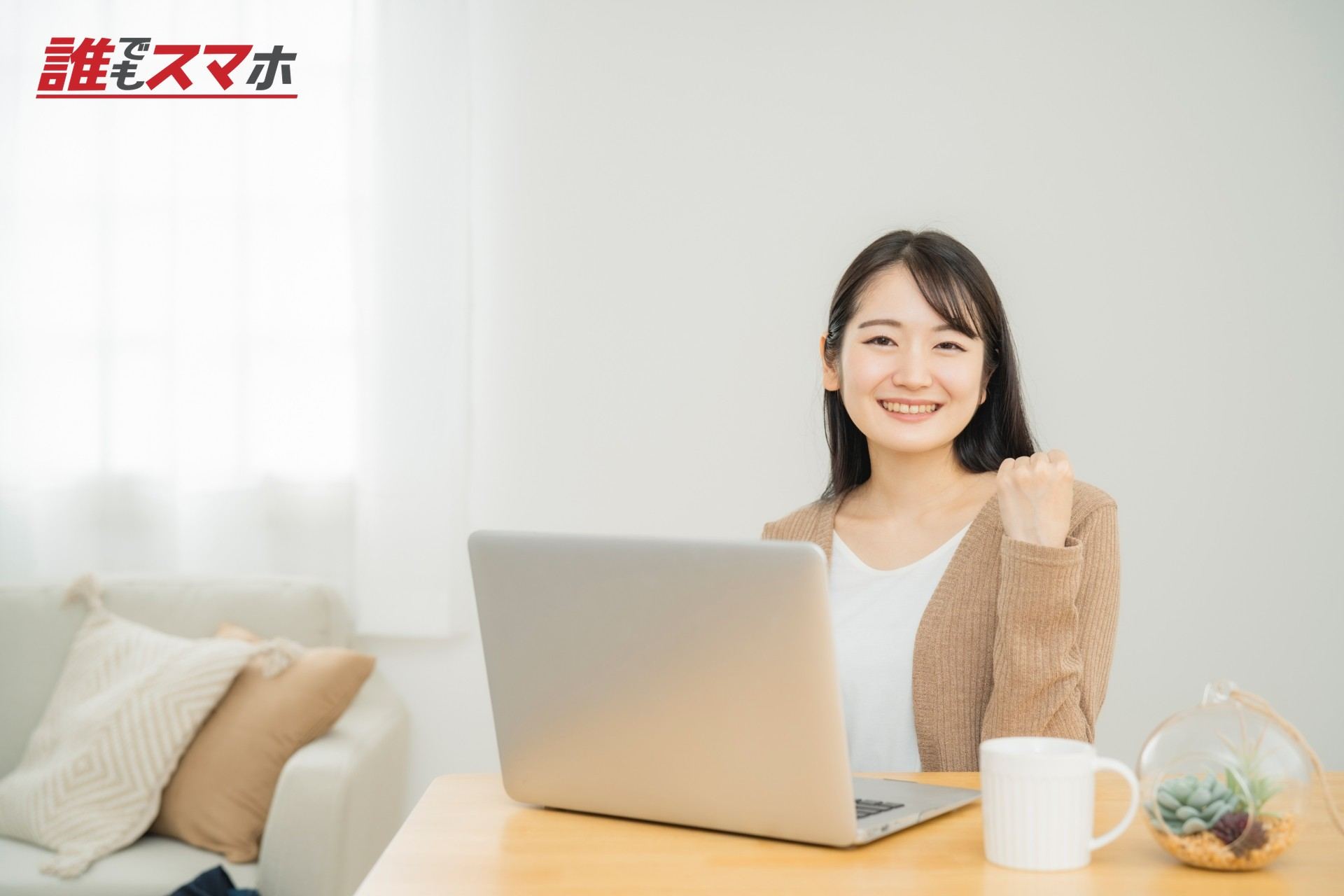 家でノートパソコンを使う女性(ガッツポーズ)
