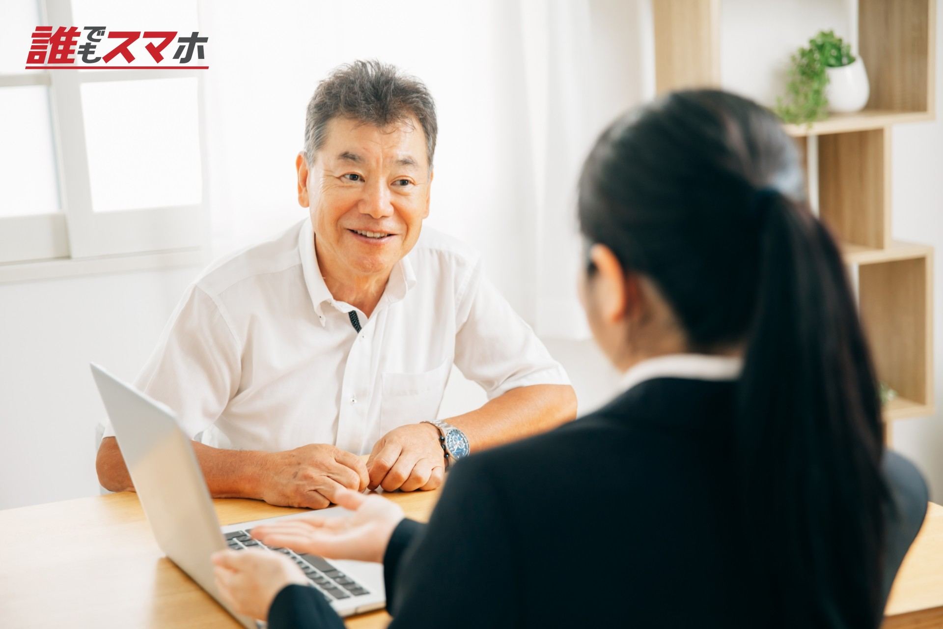 打ち合わせするスーツ姿の女性と高齢者男性