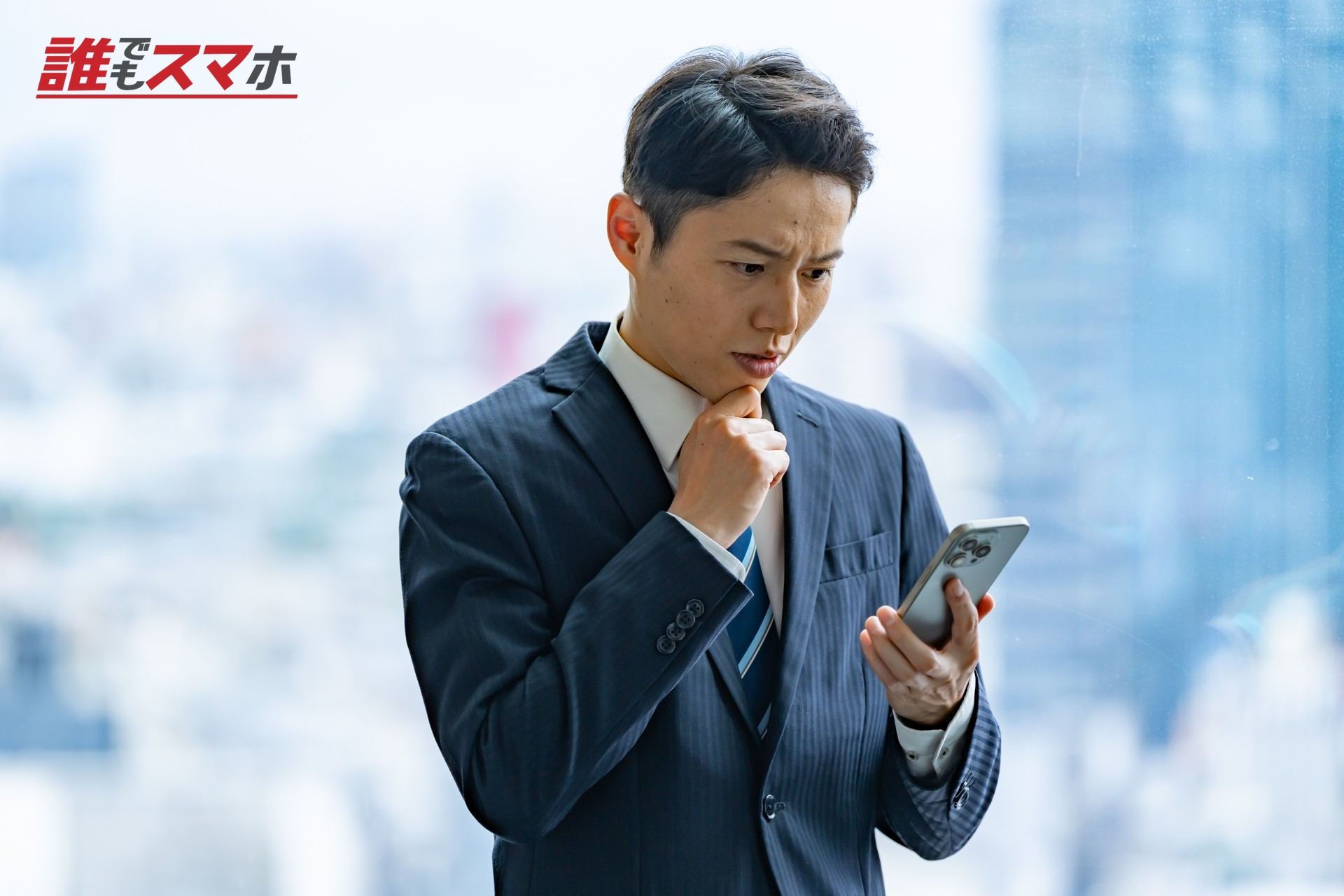 スマホを見て悩む男性